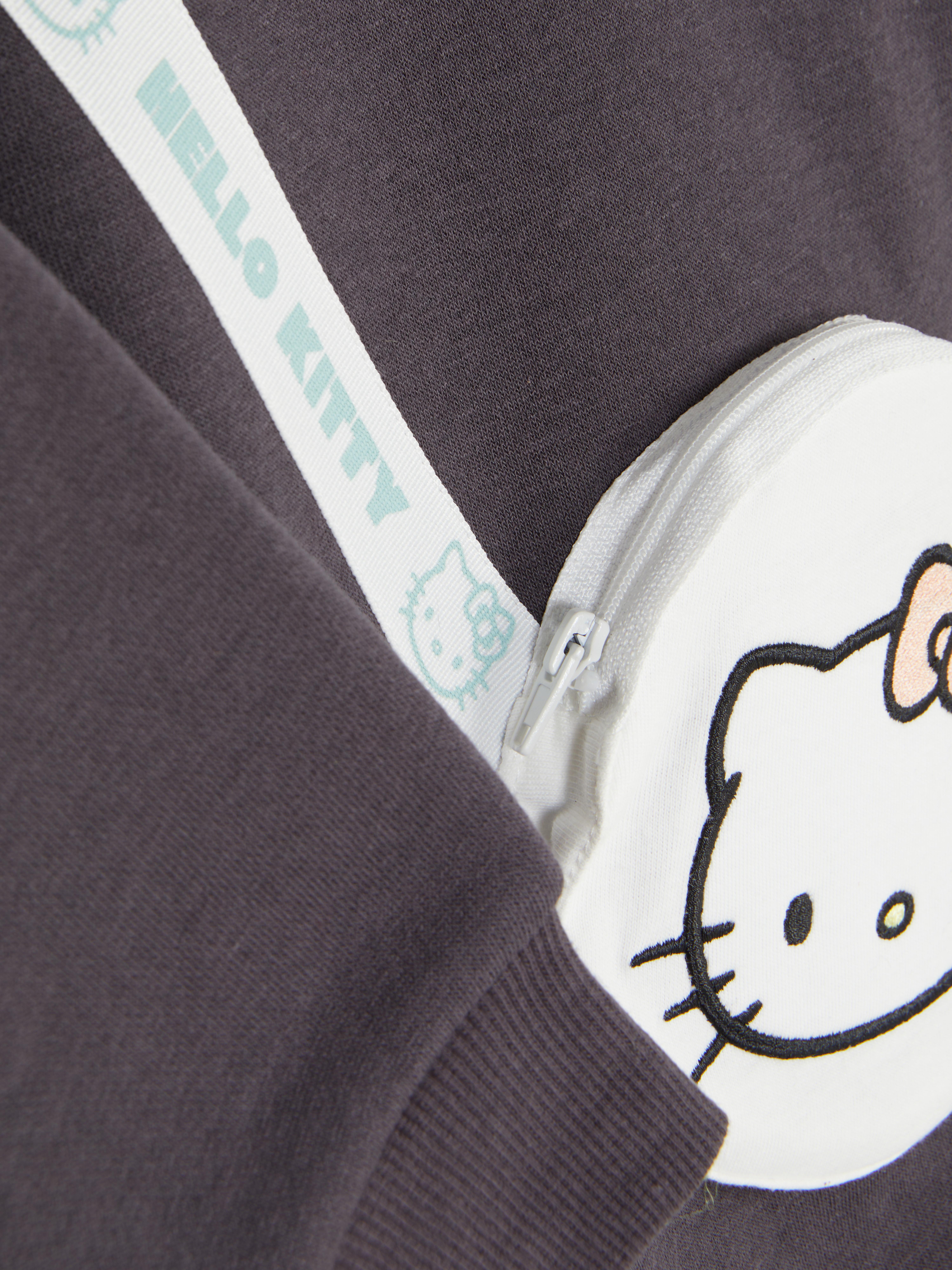 Sweatshirt mit Hello-Kitty-Schultertasche Ein langes Hello-Kitty-Sweatshirt mit einer passenden Tasche als Accessoire