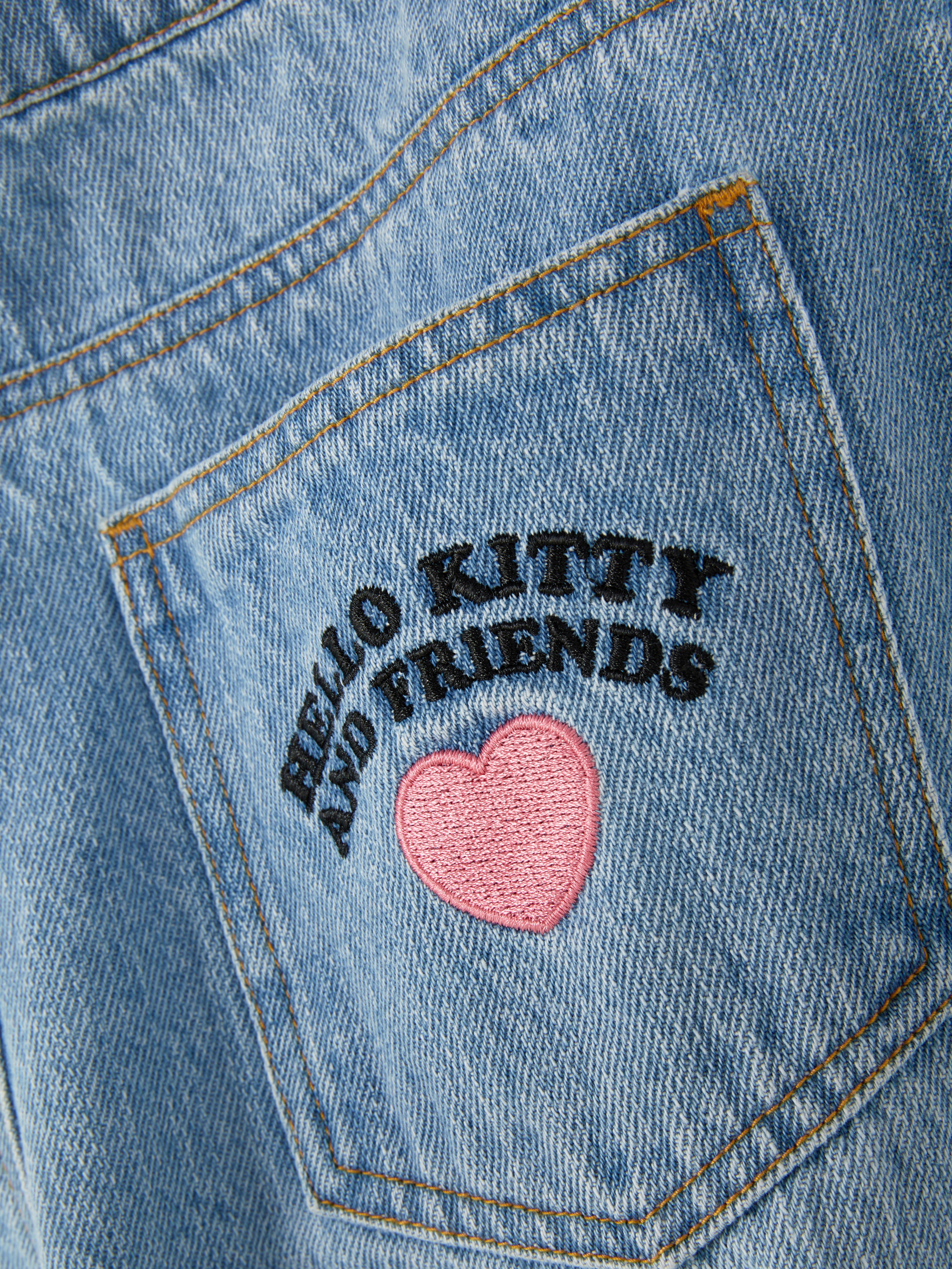 Blugi cargo Hello Kitty and Friends. Blugi utilitari cu croi larg, găici pentru curea, buzunare cargo și imprimeu cu personaje Sanrio.