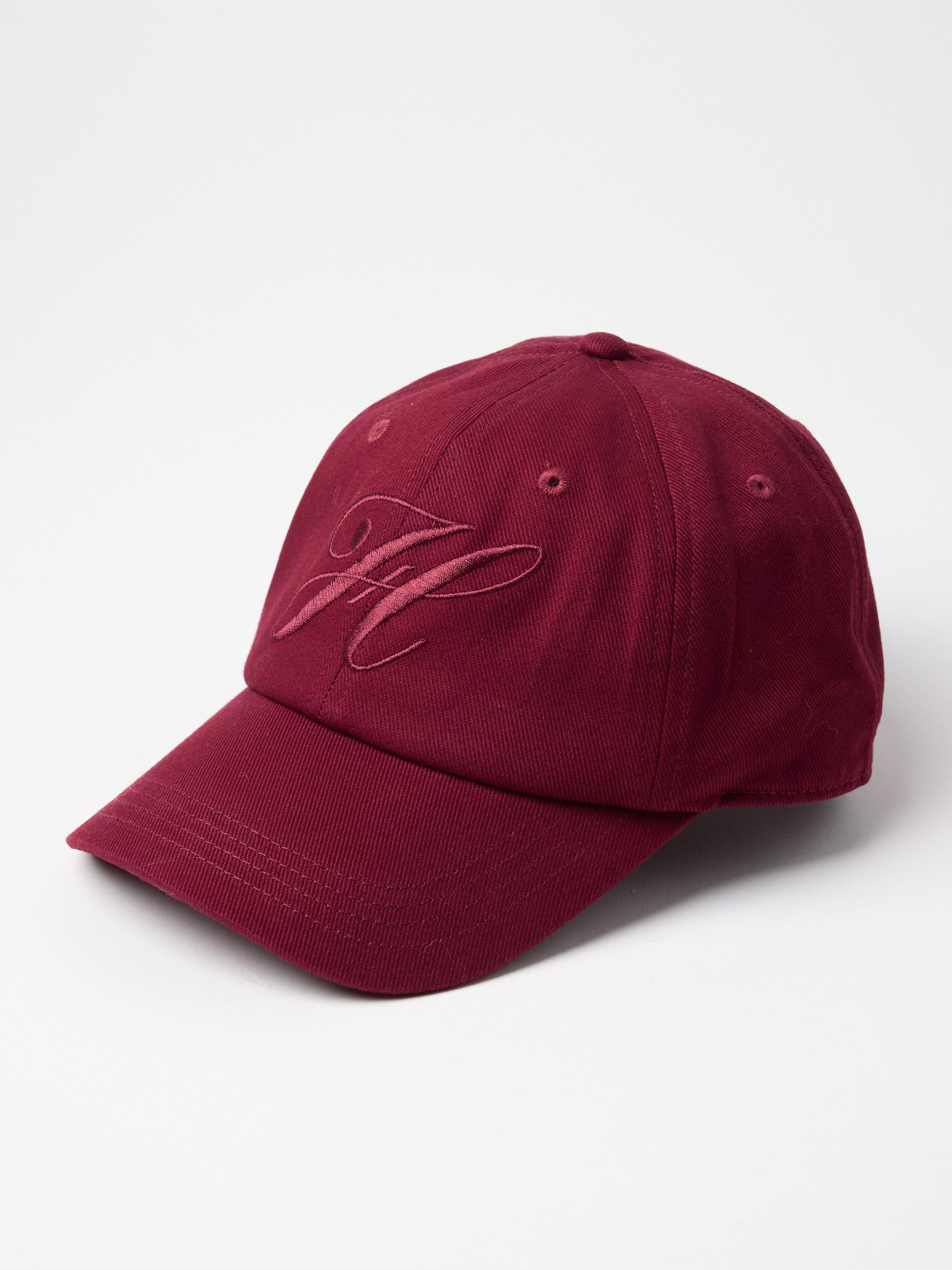 Gorra con visera redondeada, color rojo oscuro empolvado.