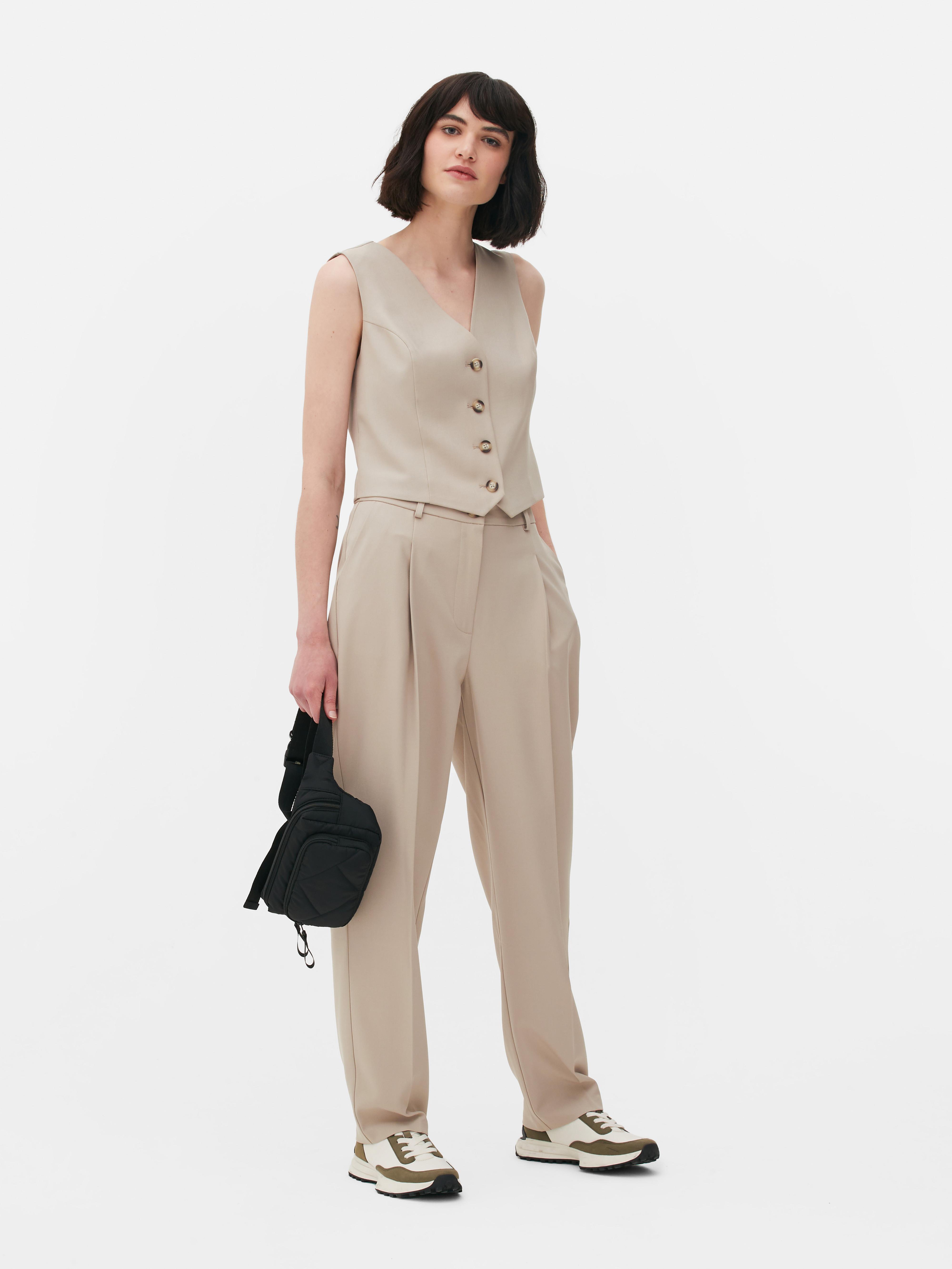 Passende Hose mit geradem Bein. Eine minimalistische Hose mit Bundfalten, geradem Schnitt und neutraler Farbe.