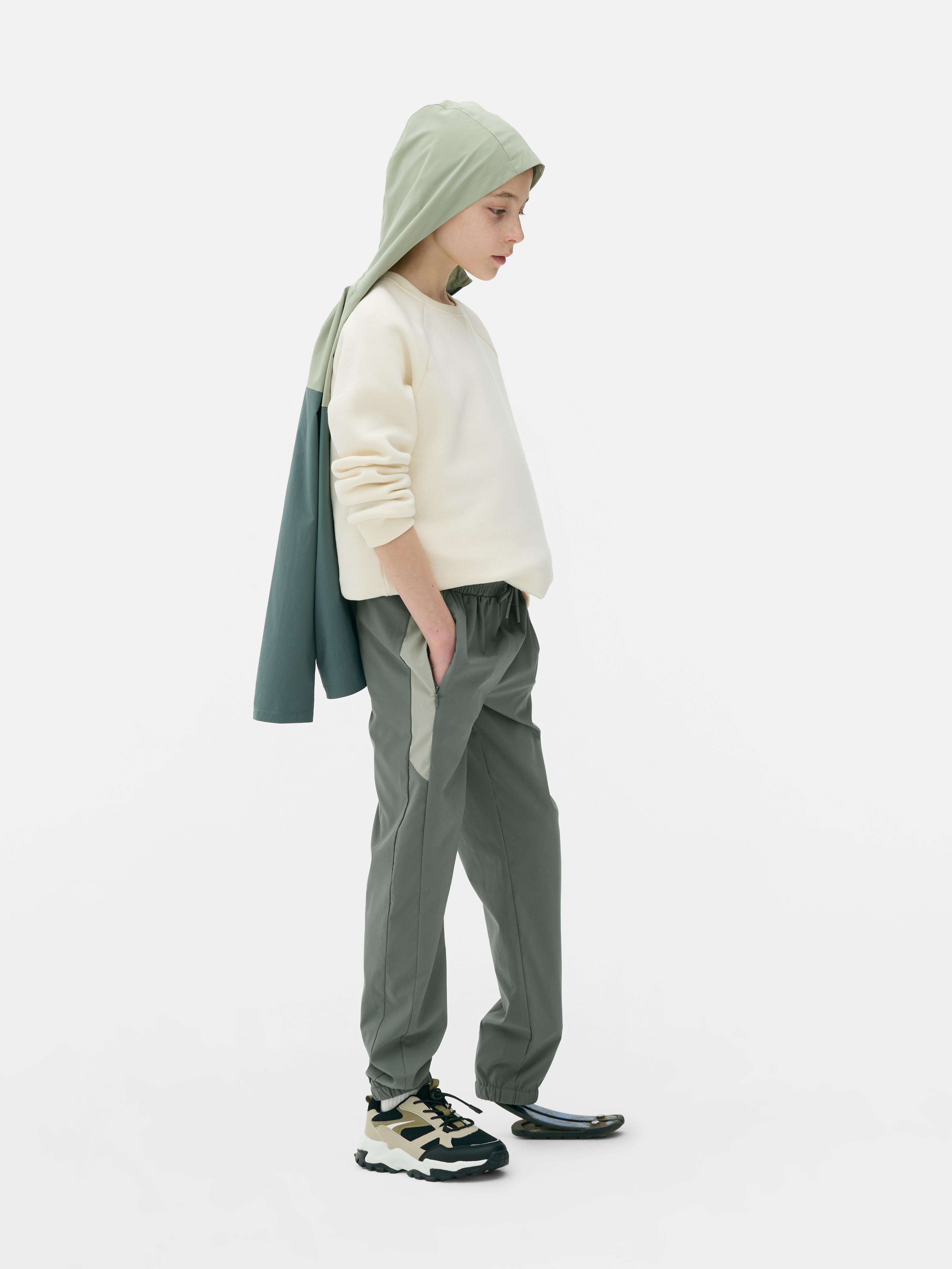 Pantaloni sport de jogging cu talie conică. Pantaloni de jogging cu talie cu șnur, buzunare cu fermoar și manșete la gleznă.