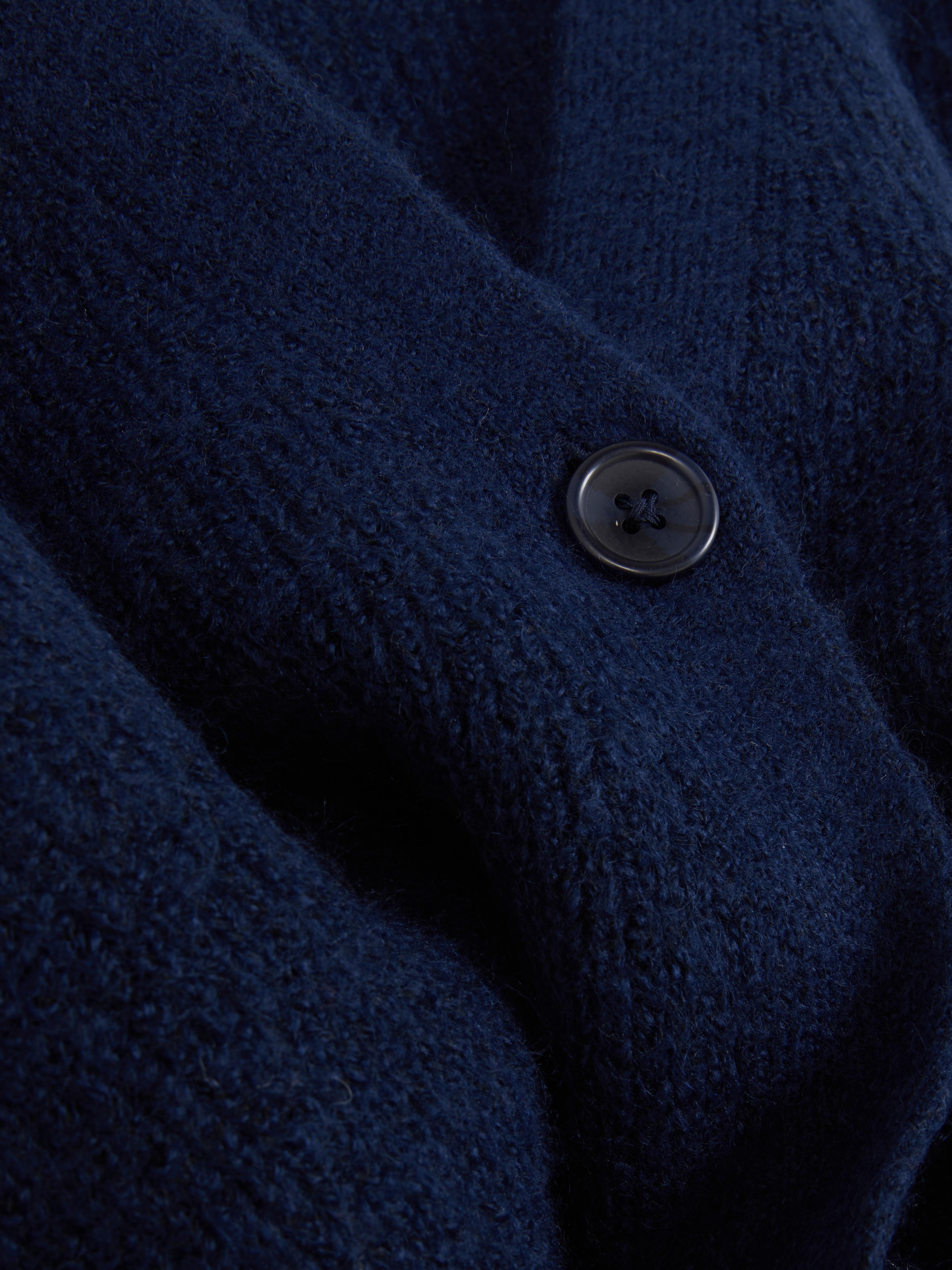 Cardigan cu decolteu în V și croială lejeră. Acest cardigan cu nasturi, croială lejeră și umeri căzuți este un clasic elegant.