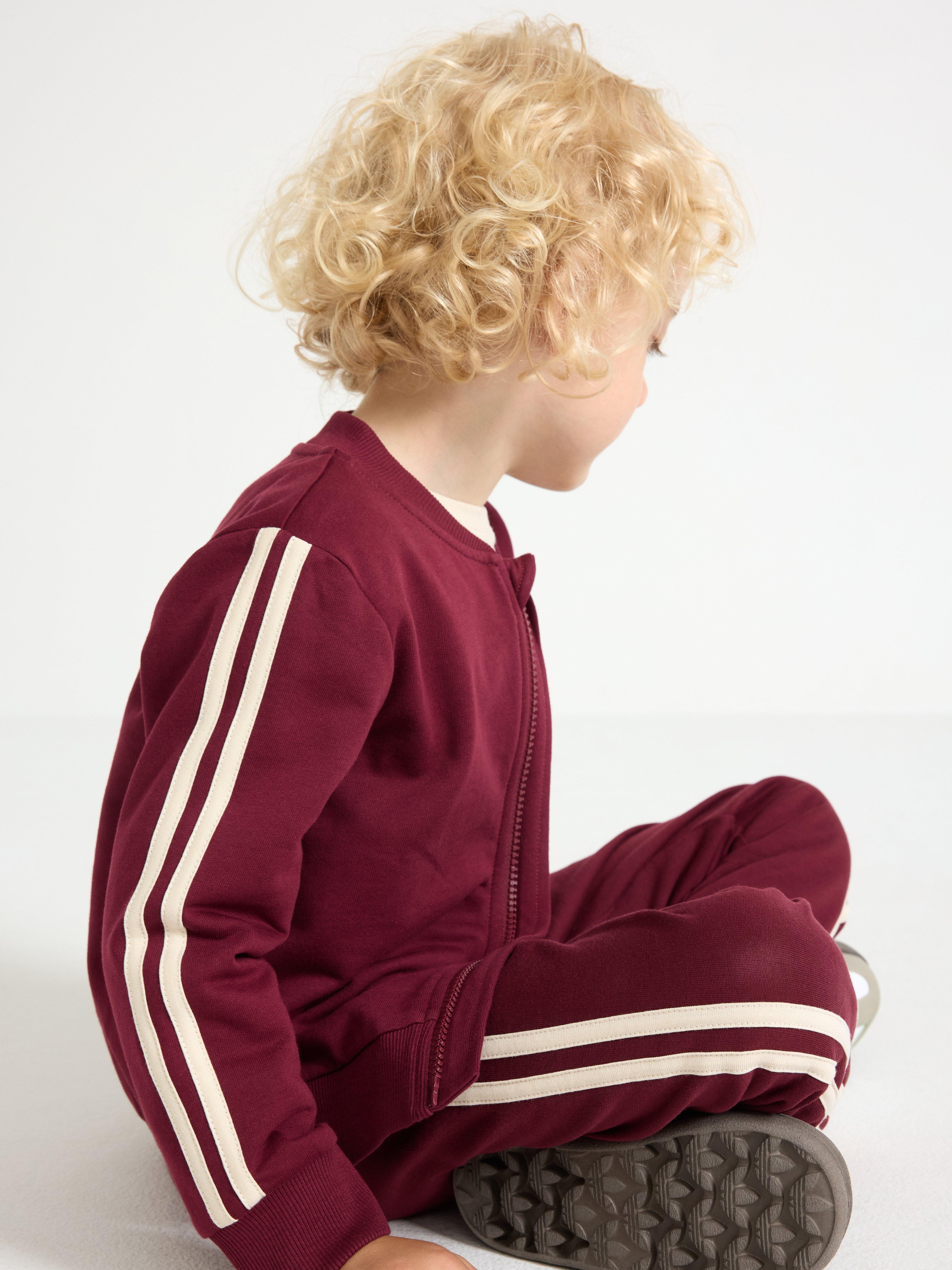 Sudadera con cremallera, color rojo oscuro empolvado.