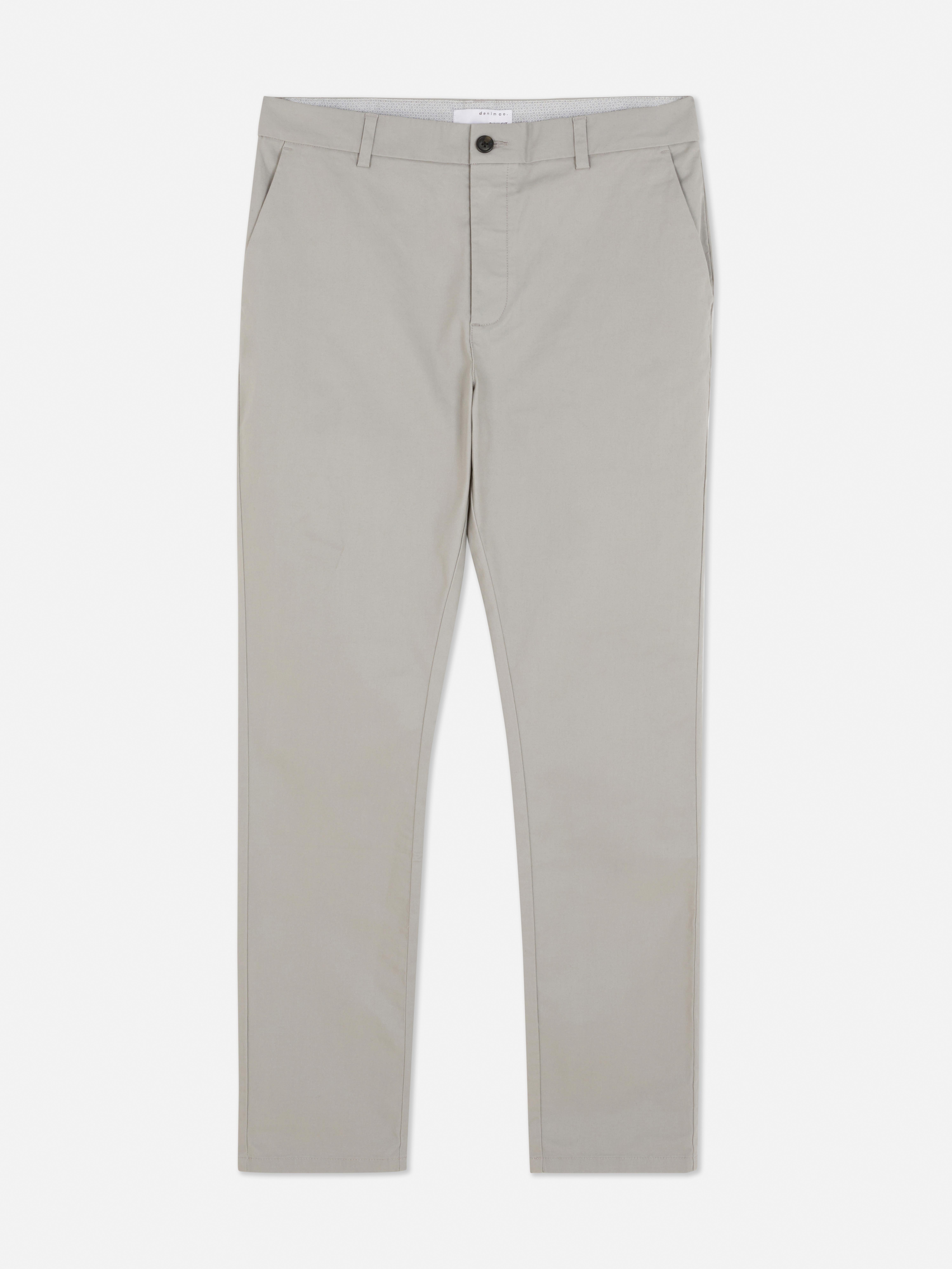 Pantaloni chino elastici, mulați. Pantaloni chino mulați, confecționați în principal din bumbac și cu buzunare laterale.