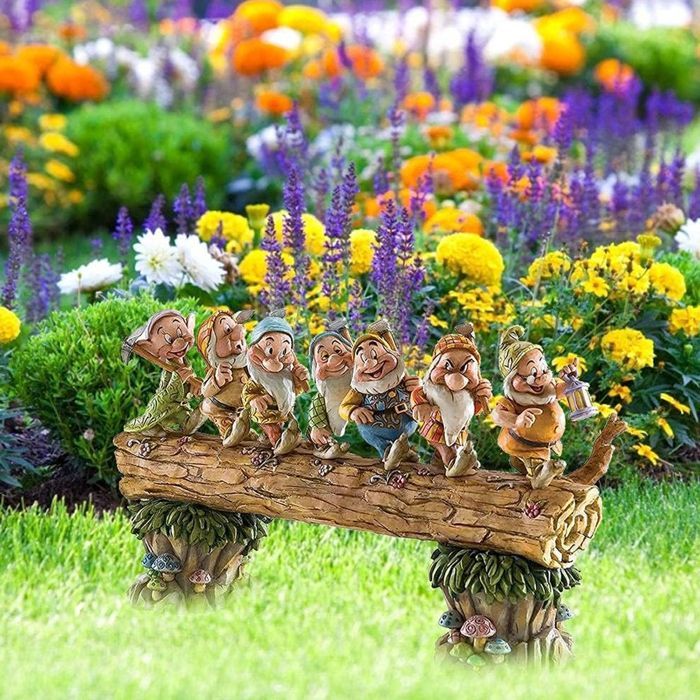 Sette alberi nani adornano il giardino, insieme a una statuetta in resina in miniatura raffigurante un nano.
