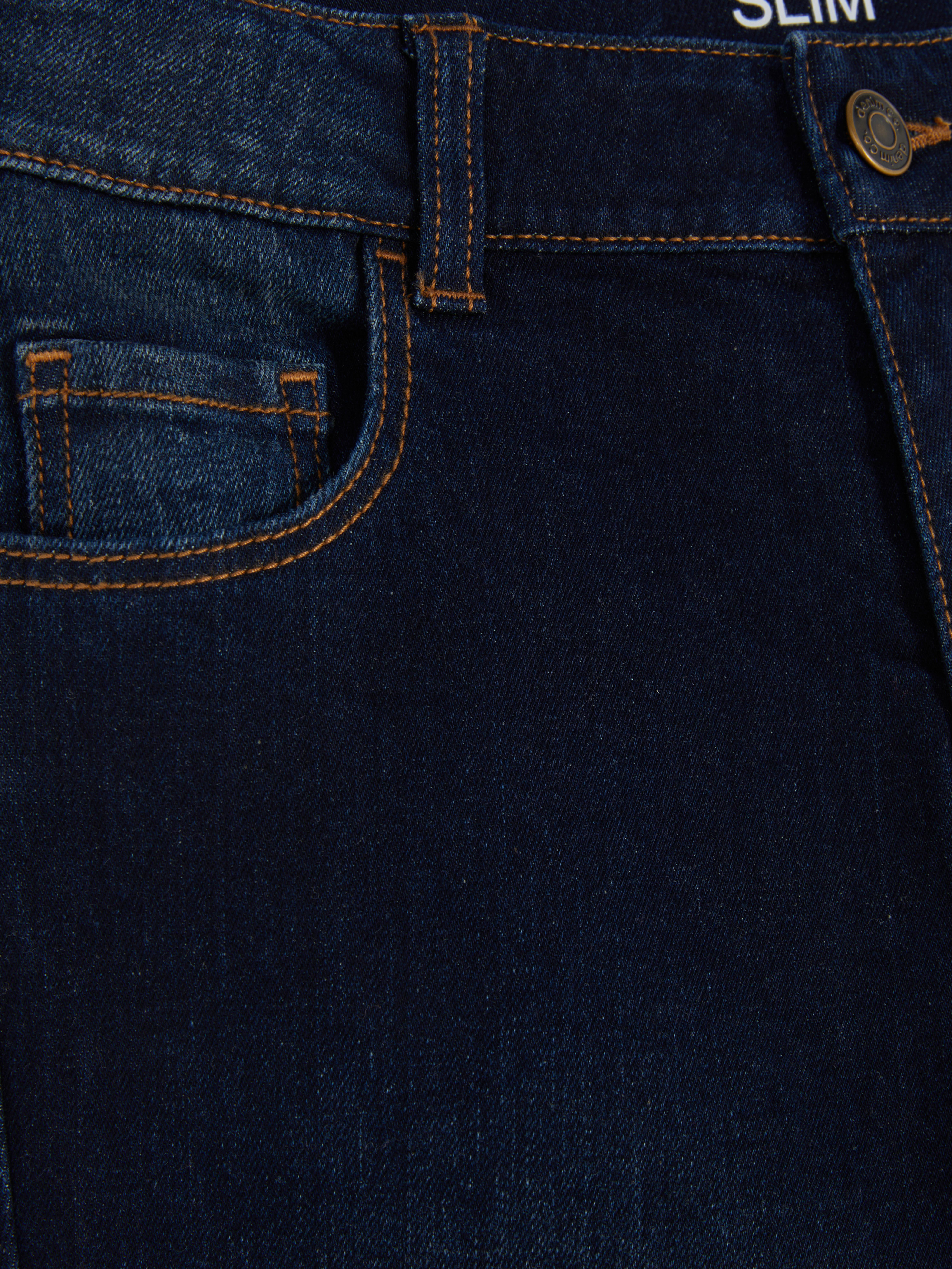 Schmal geschnittene Jeans für Jungen. Diese schmal geschnittenen Jeans mit Gürtelschlaufen und Knöpfen verleihen ihrer Jeanskollektion das gewisse Extra.