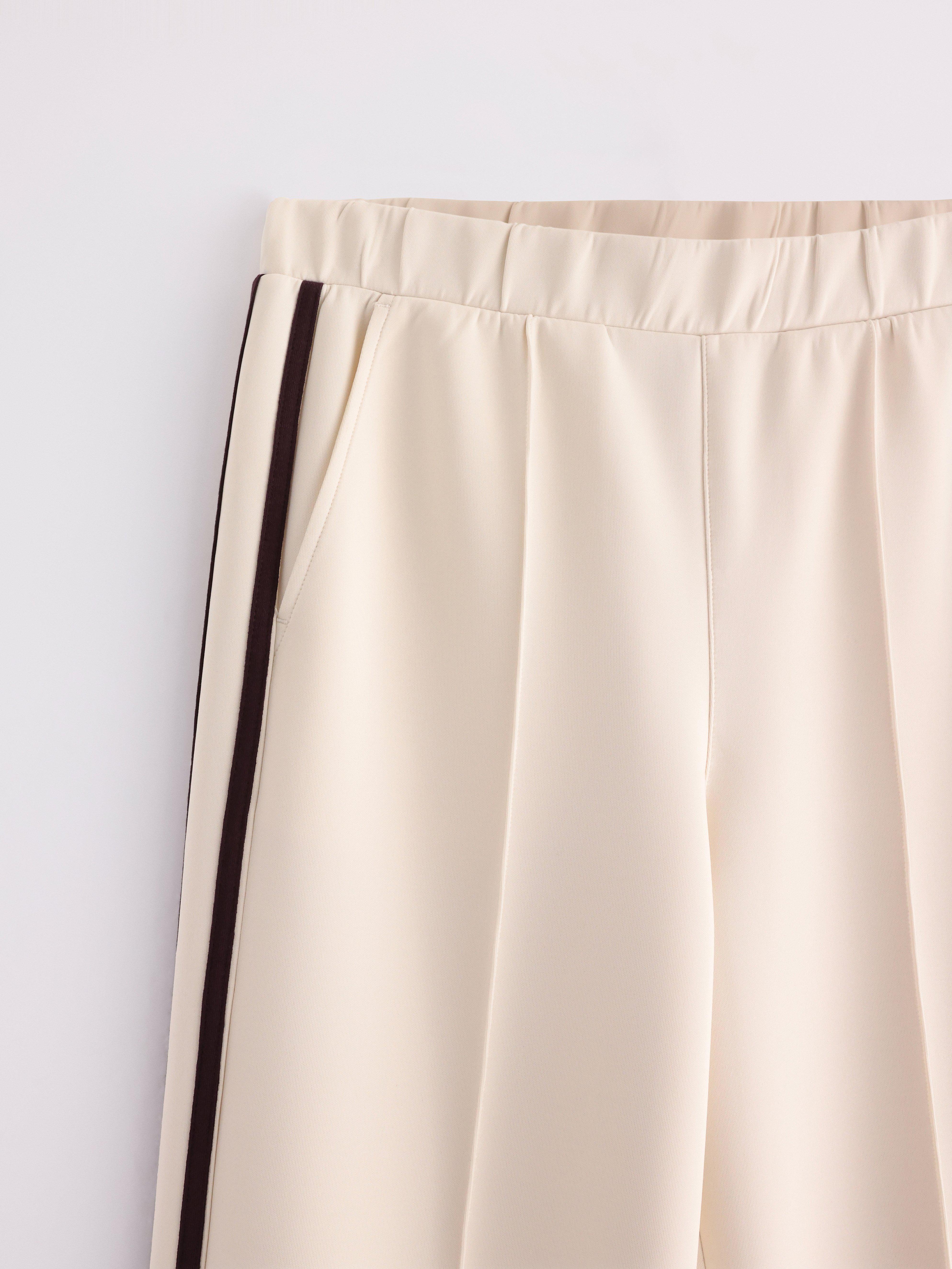Pantalones anchos de punto color beige claro.