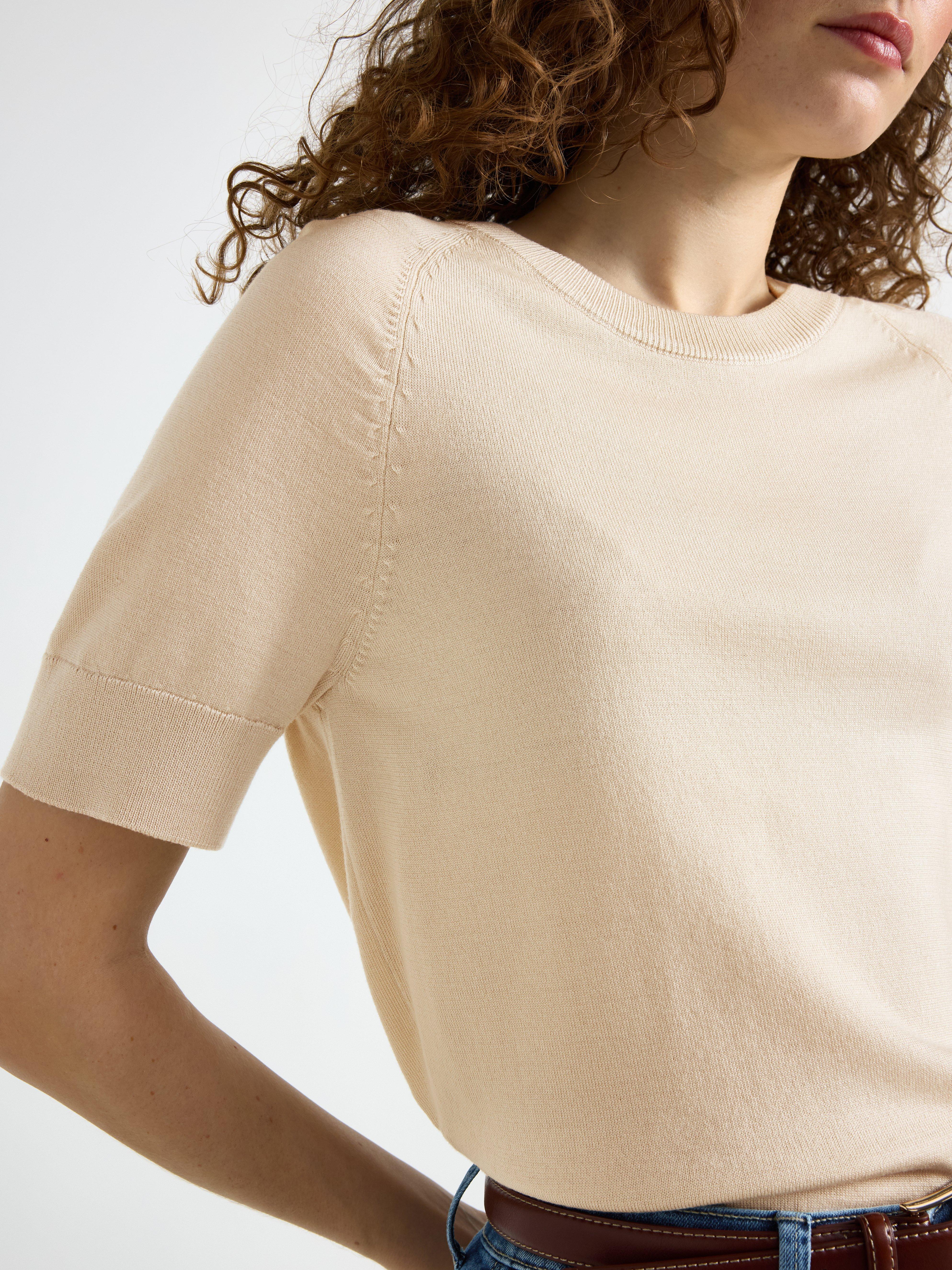 Jersey de punto fino color beige claro.