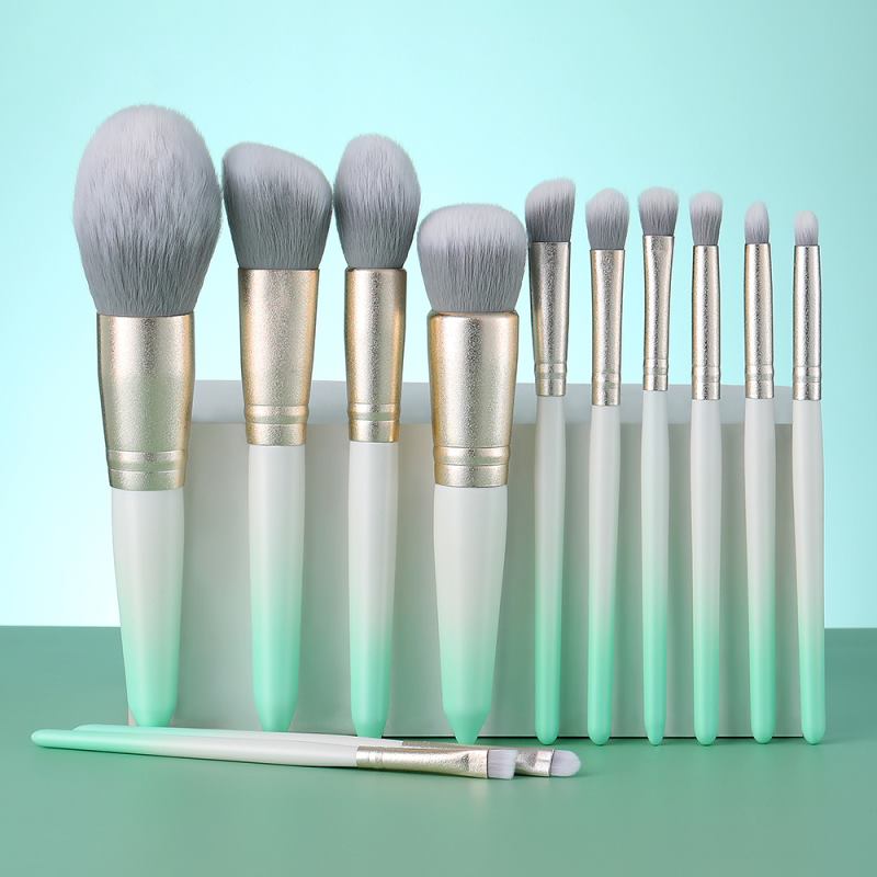 Ensemble de pinceaux de maquillage verts (12 pièces) : pinceaux à sourcils, à fond de teint, à blush et à poudre. Outils de beauté et cosmétiques.