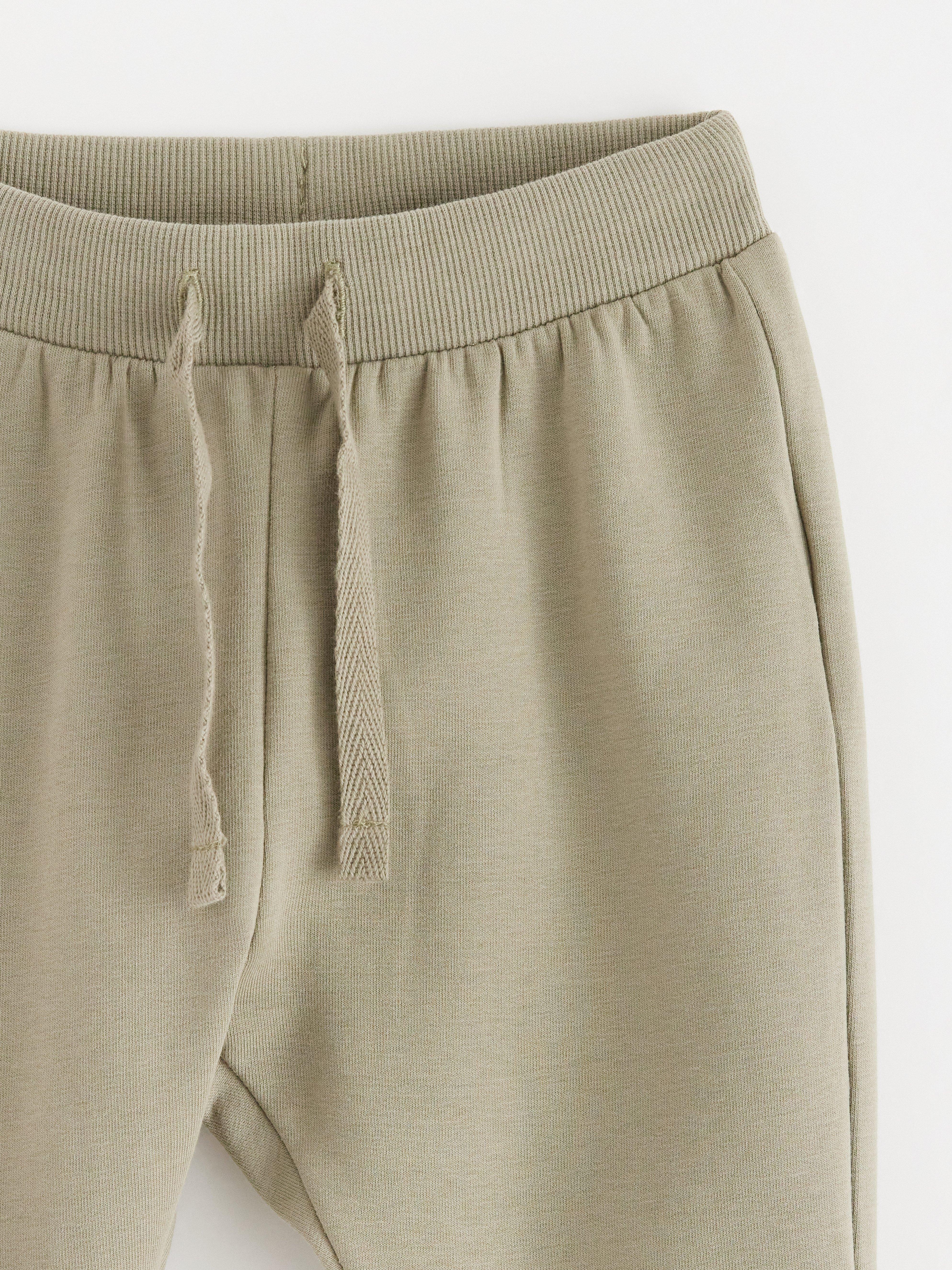 Pantalones deportivos con interior cepillado, color caqui claro empolvado.