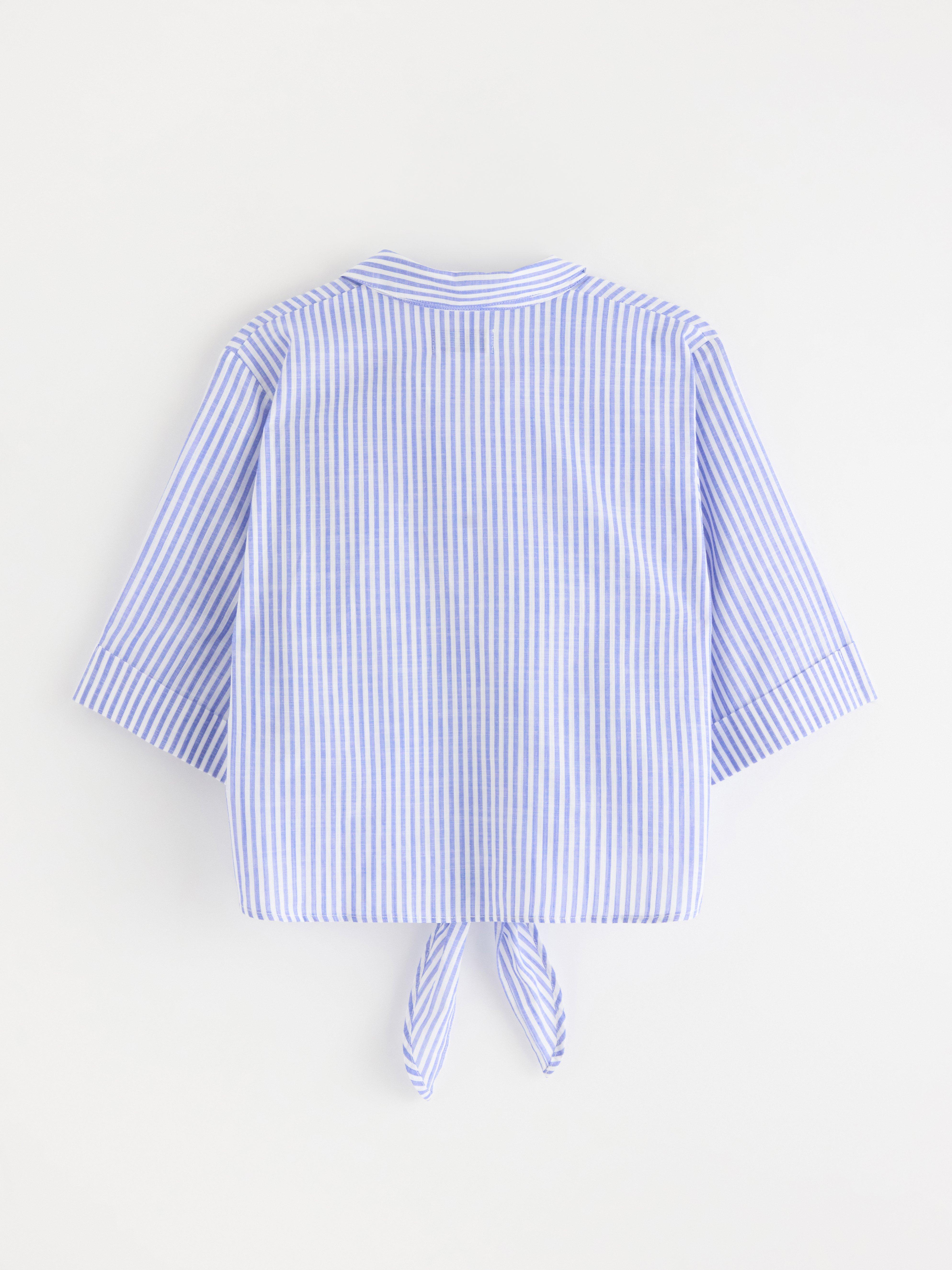 Blusa com amarração na cintura, azul forte.