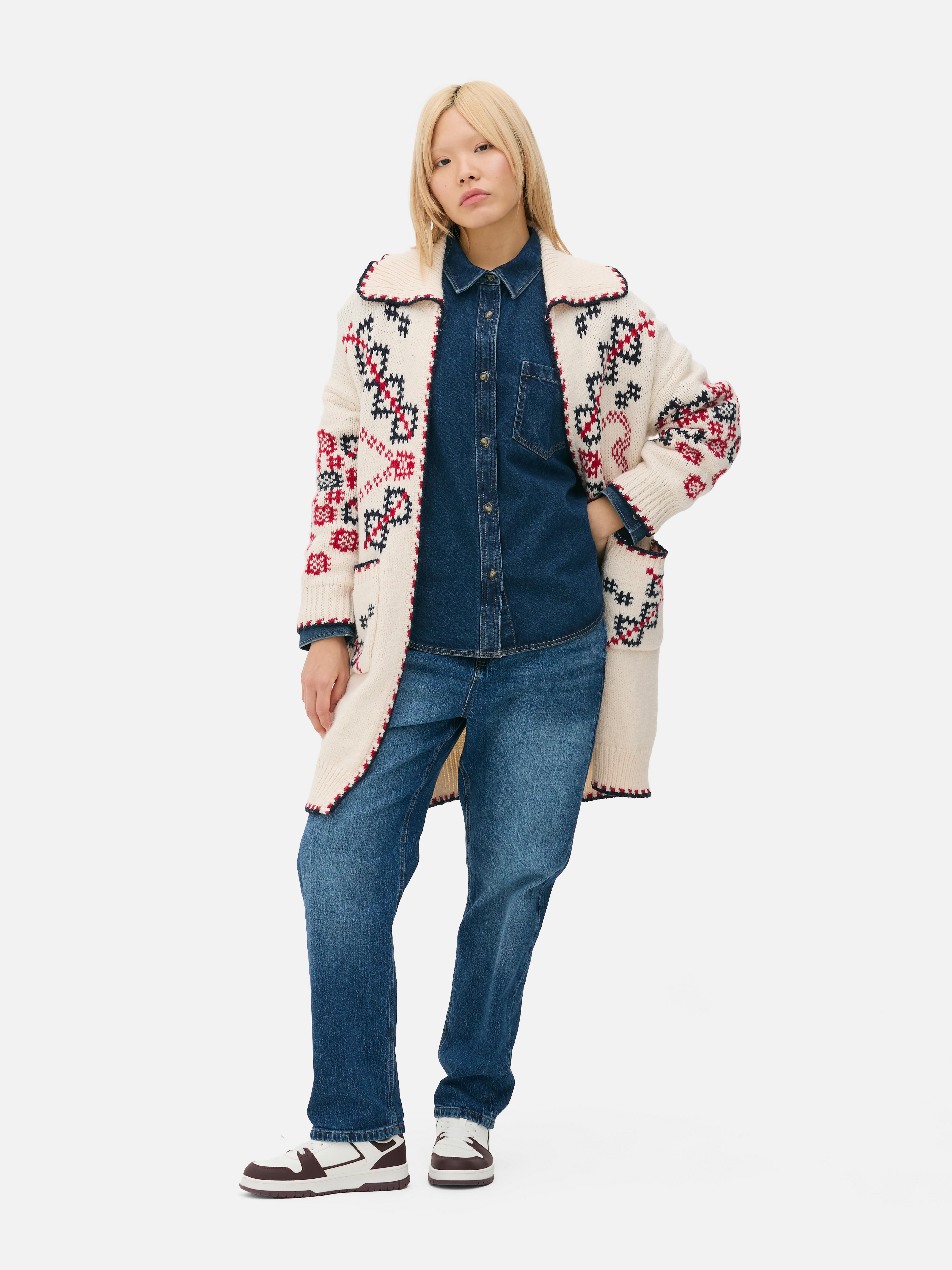 Gilet long en maille à motif cœur. Gilet long en maille avec col, ceinture à nouer, poches et poignets côtelés.