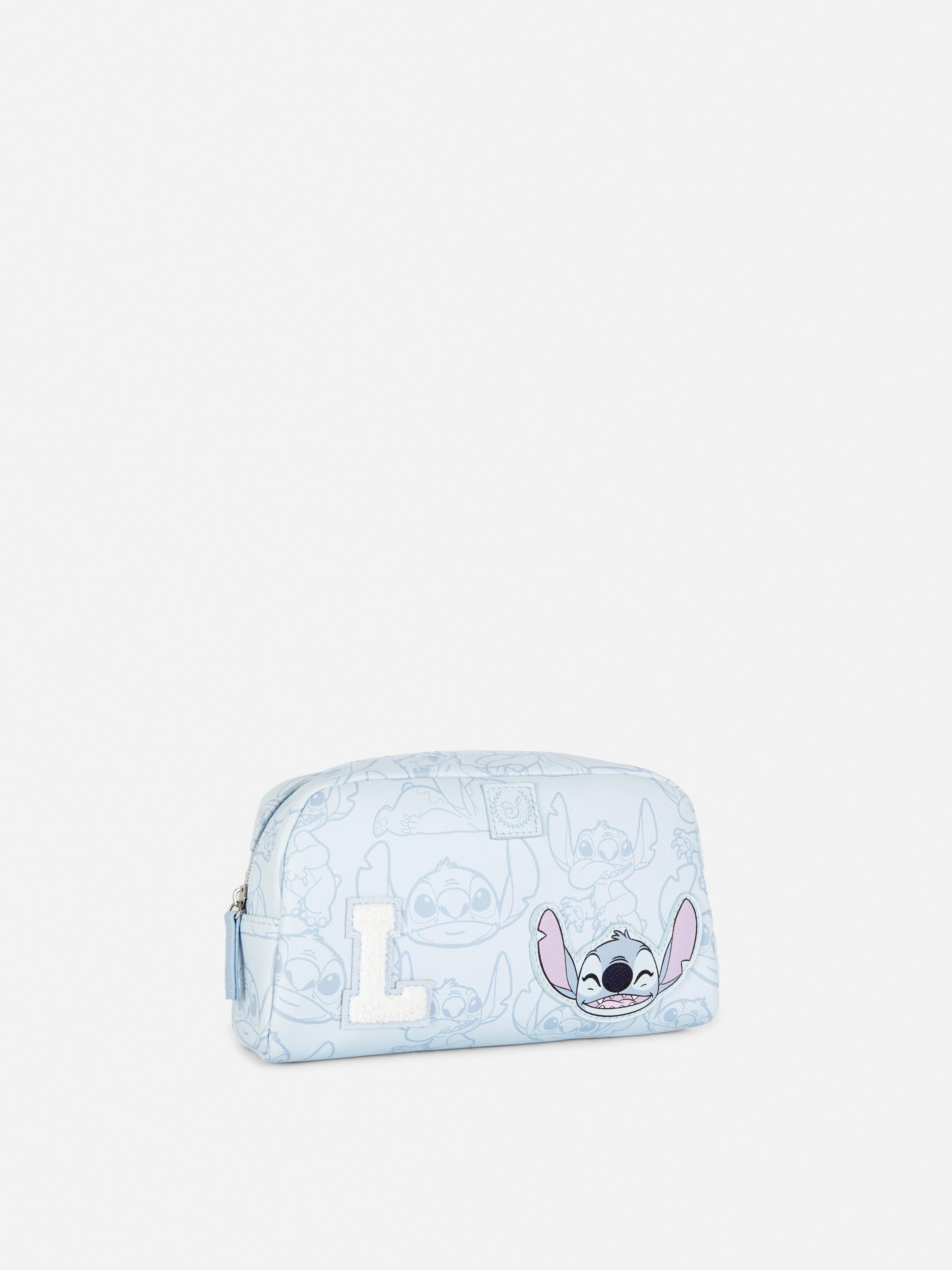 Torbica za ličila z aplikacijo Disneyjevih začetnic Stitch. Majhna torbica za ličila z aplikacijo začetnic in Disneyjevim dizajnom Stitch.
