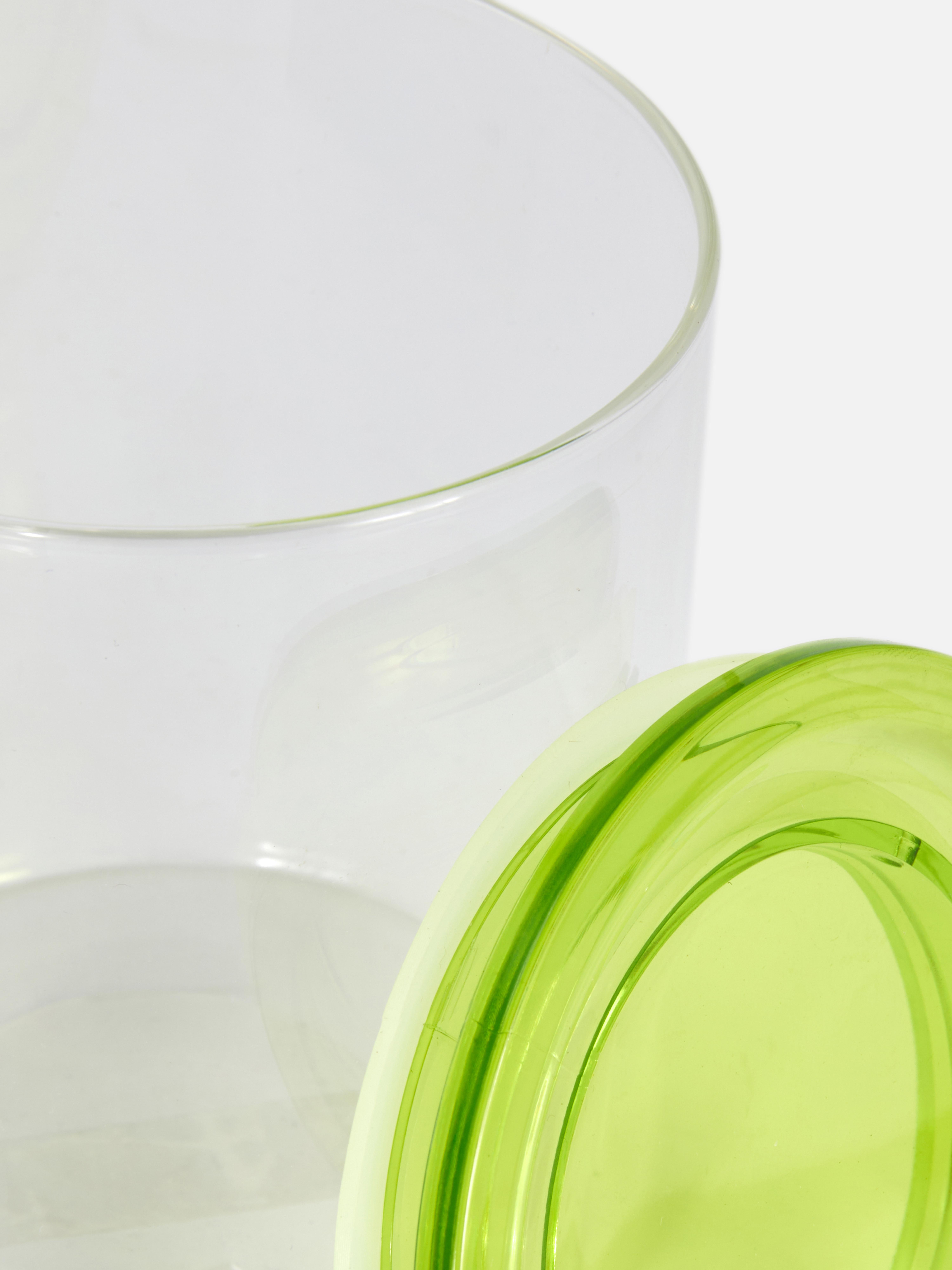 Small glass storage jar A small glass jar with a colored lid for organized storage