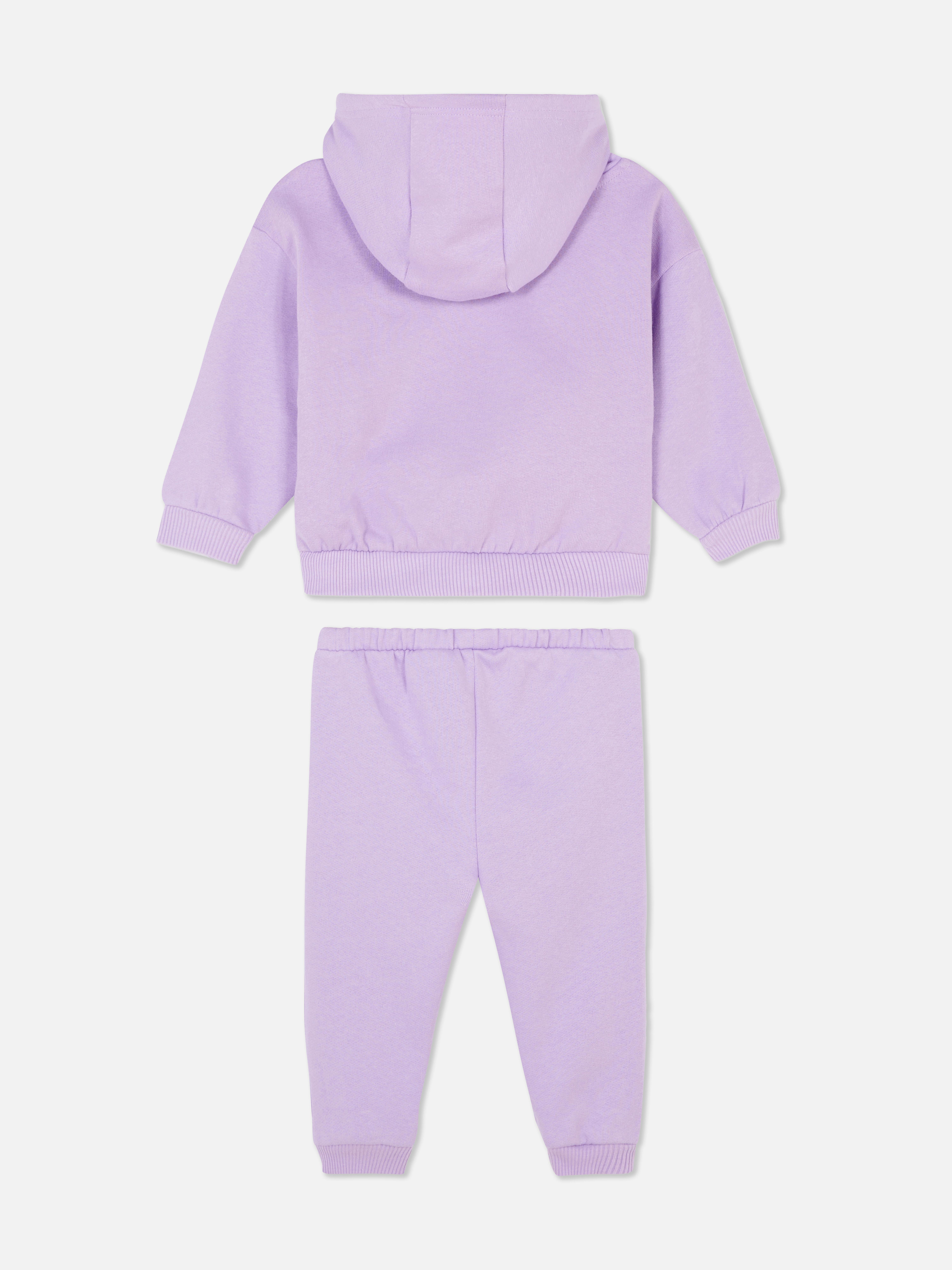 Completo casual composto da felpa con cappuccio e pantaloni della tuta con polsini alla caviglia.