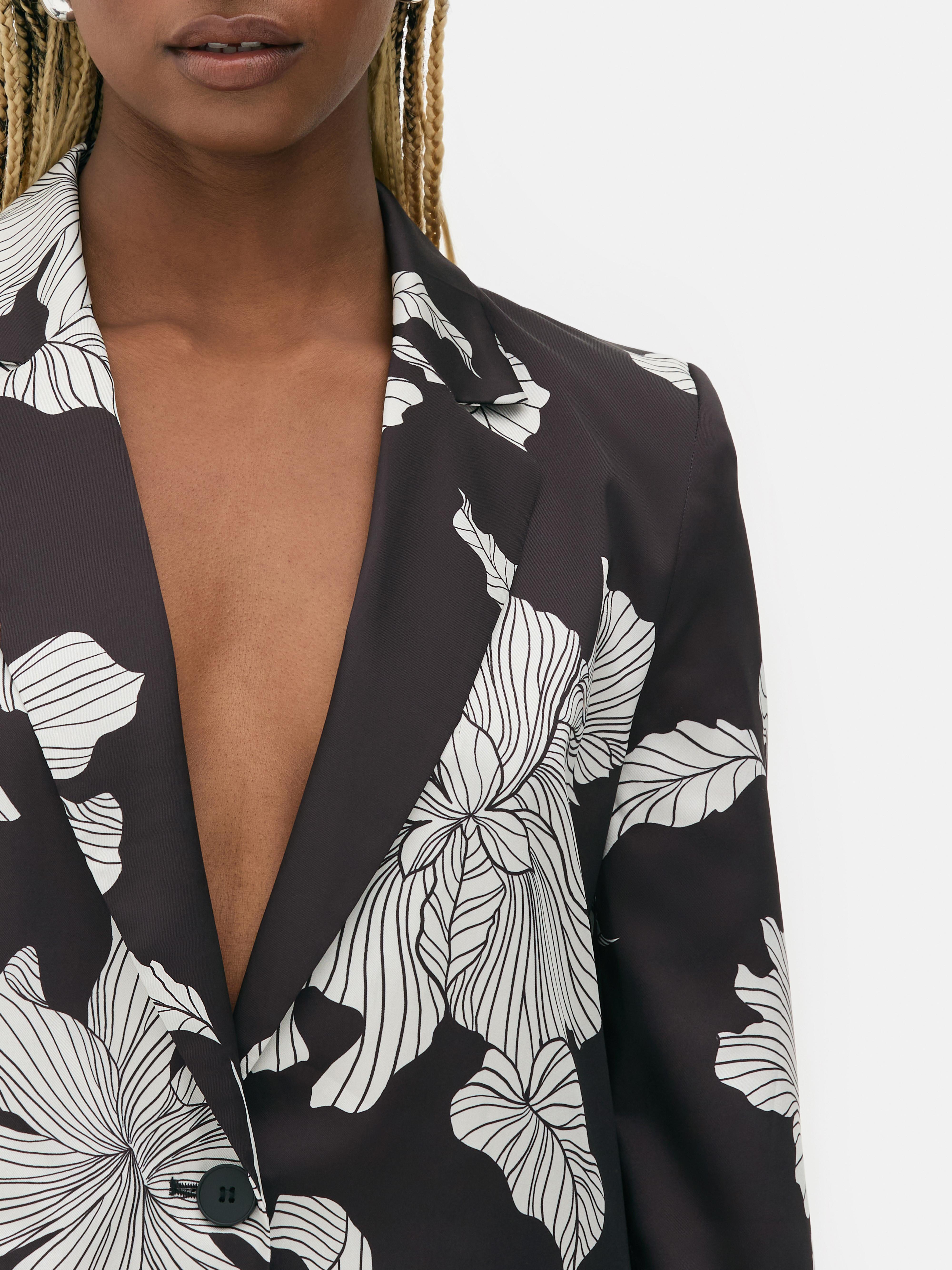 Sacou satinat cu un singur rând de nasturi. Acest sacou smoking cu model floral contrastant are pantaloni asortați.