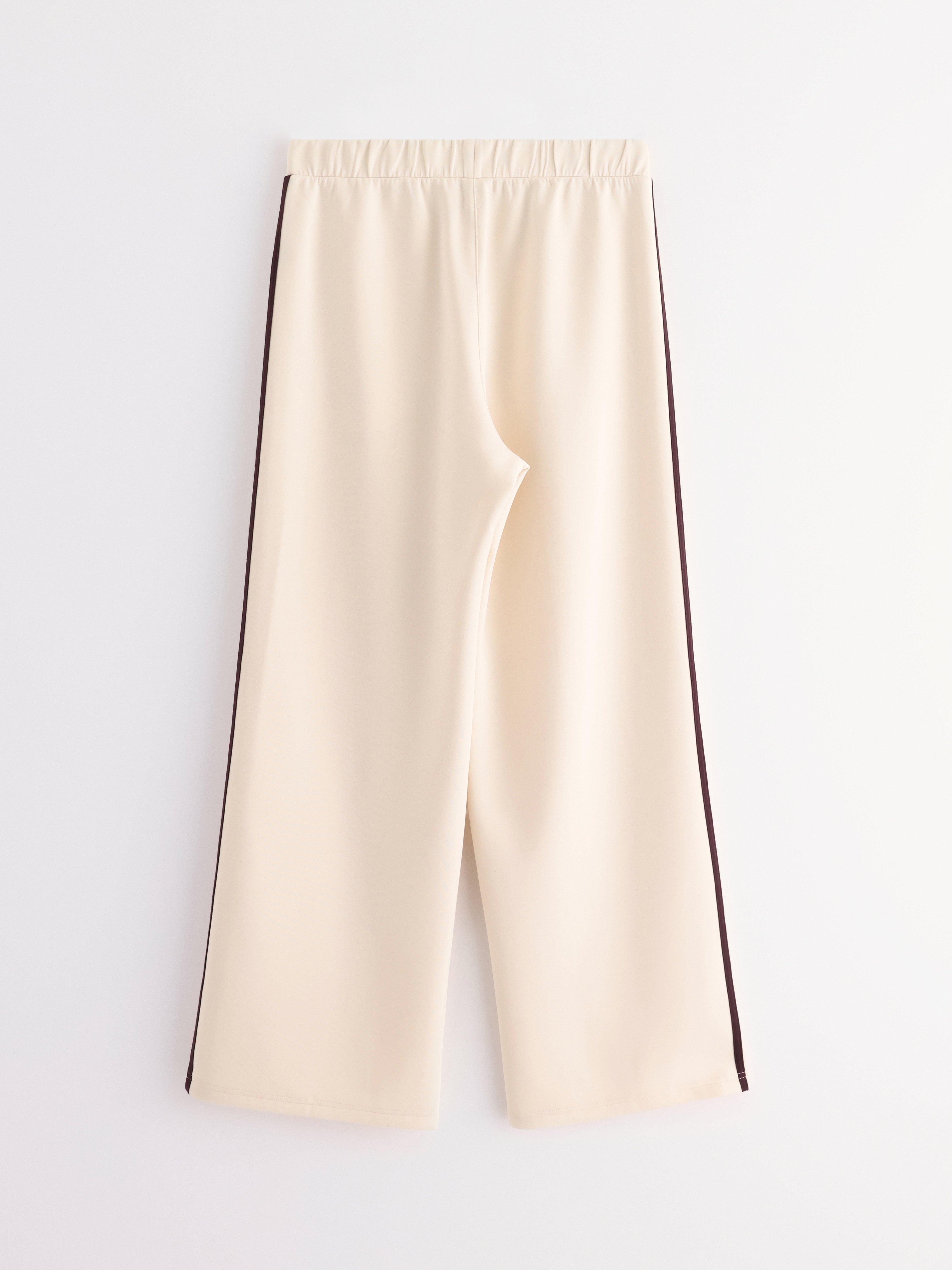 Pantalones anchos de punto color beige claro.