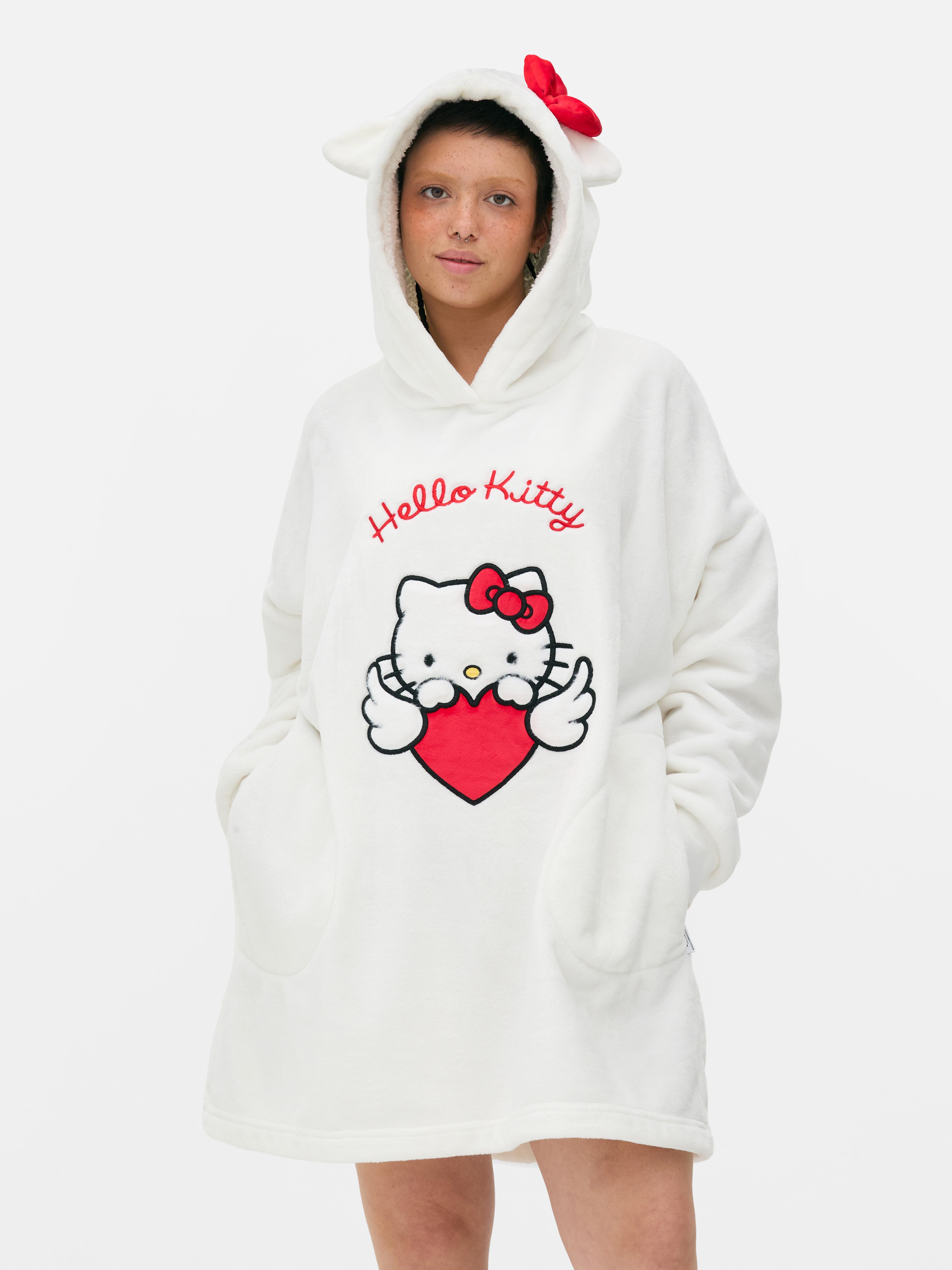 Snuddie Hello Kitty O snuddie Hello Kitty cu glugă, urechi decorative și fundă roșie emblematică
