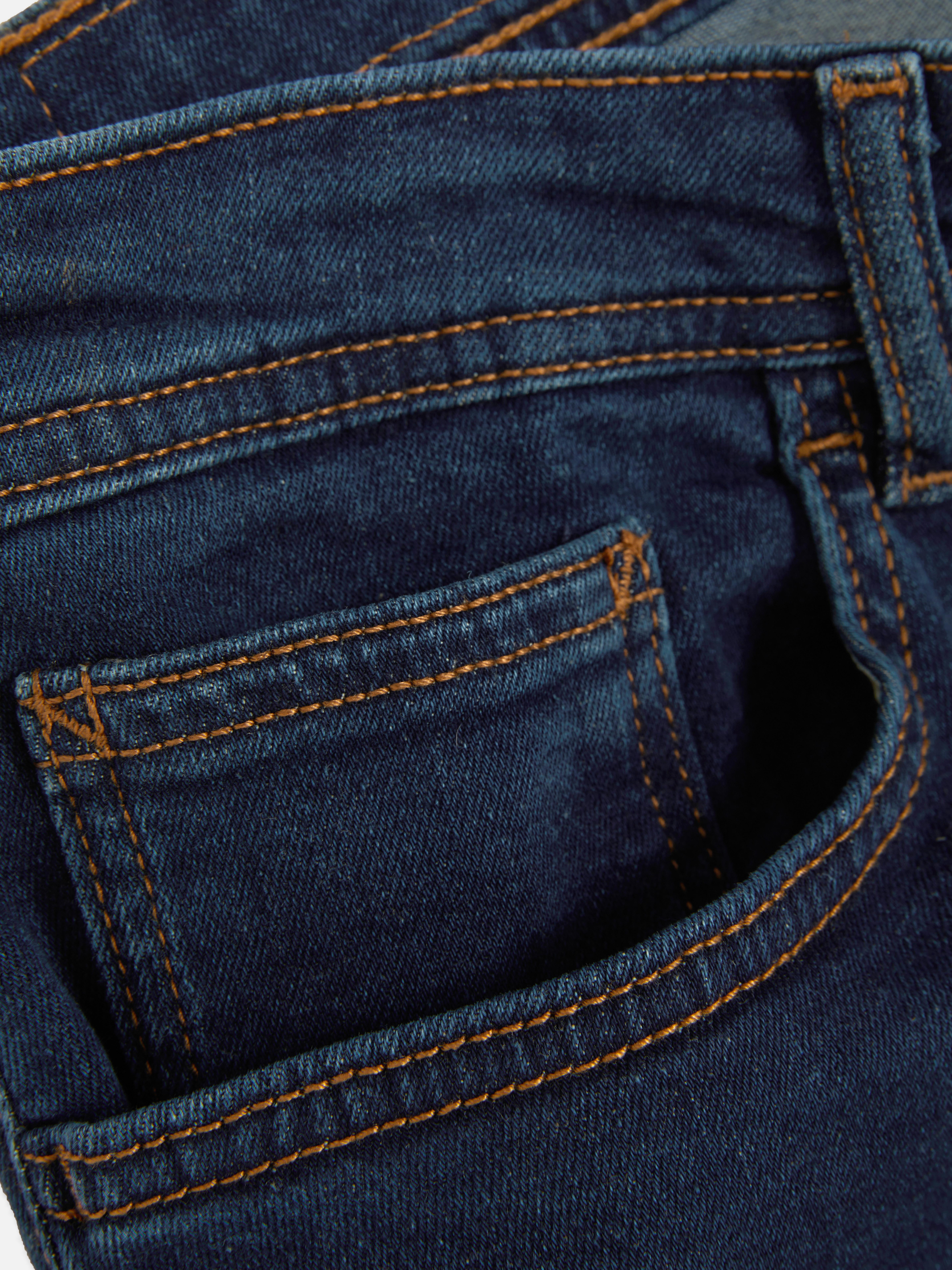 Blugi elastici, slim fit. Blugi mulați cu închidere cu nasturi, cinci buzunare și găici pentru curea.
