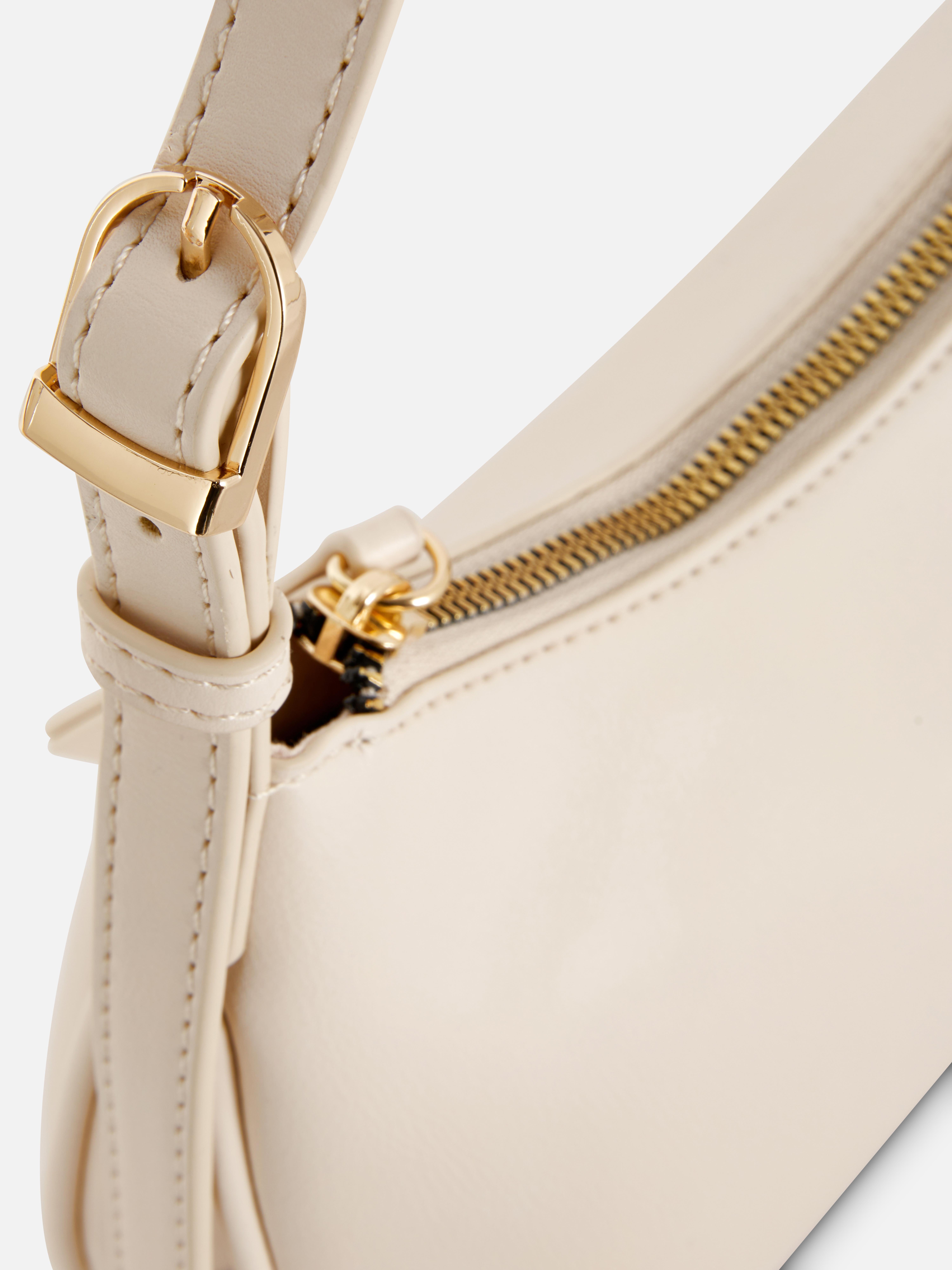 Schultertasche aus Kunstleder. Eine Tasche aus Kunstleder mit Reißverschluss und verstellbarem Schultergurt.