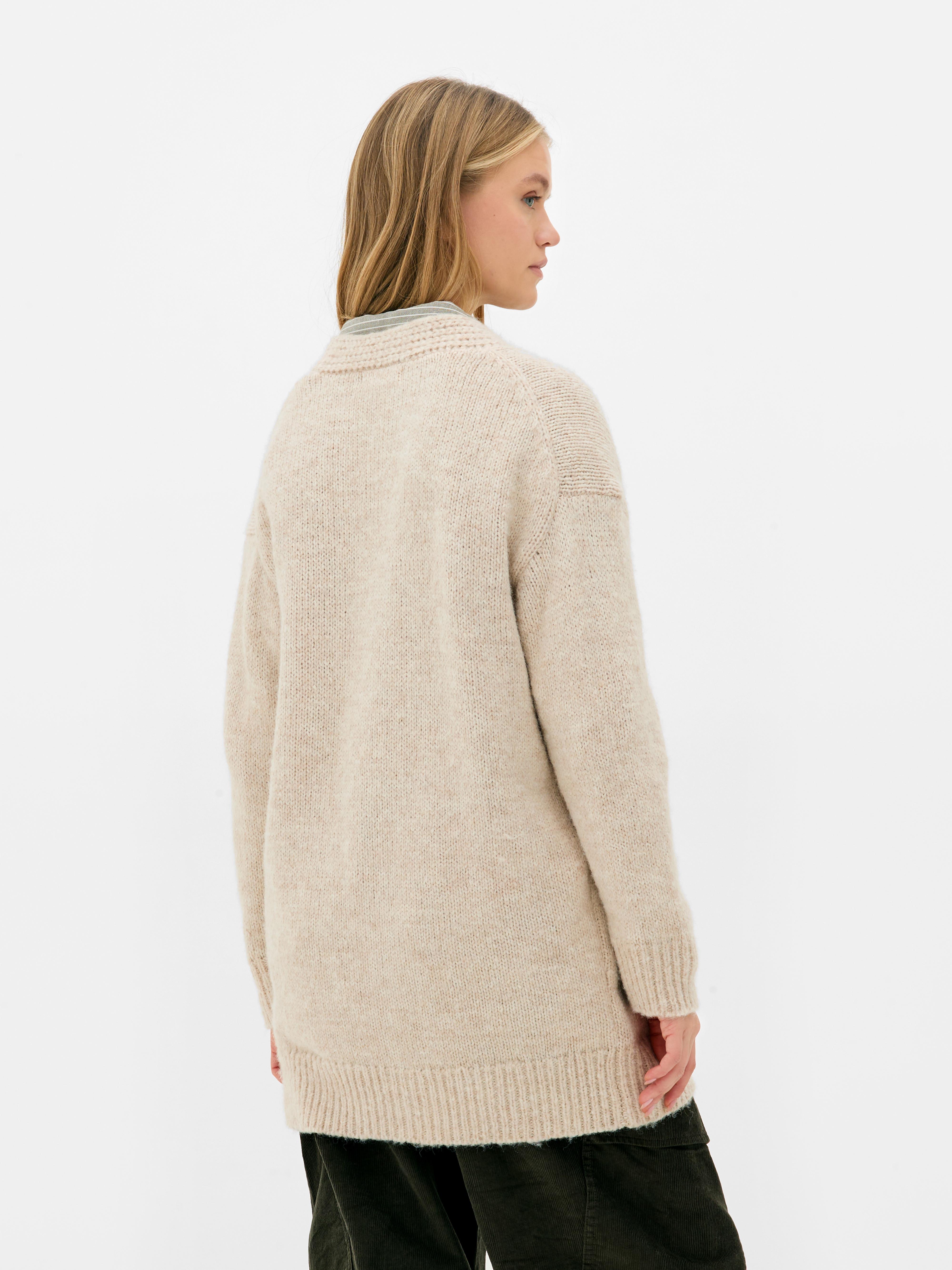 Oversize-Strickjacke. Eine lange Strickjacke mit Oversize-Schnitt, V-Ausschnitt und aufgesetzten Taschen.