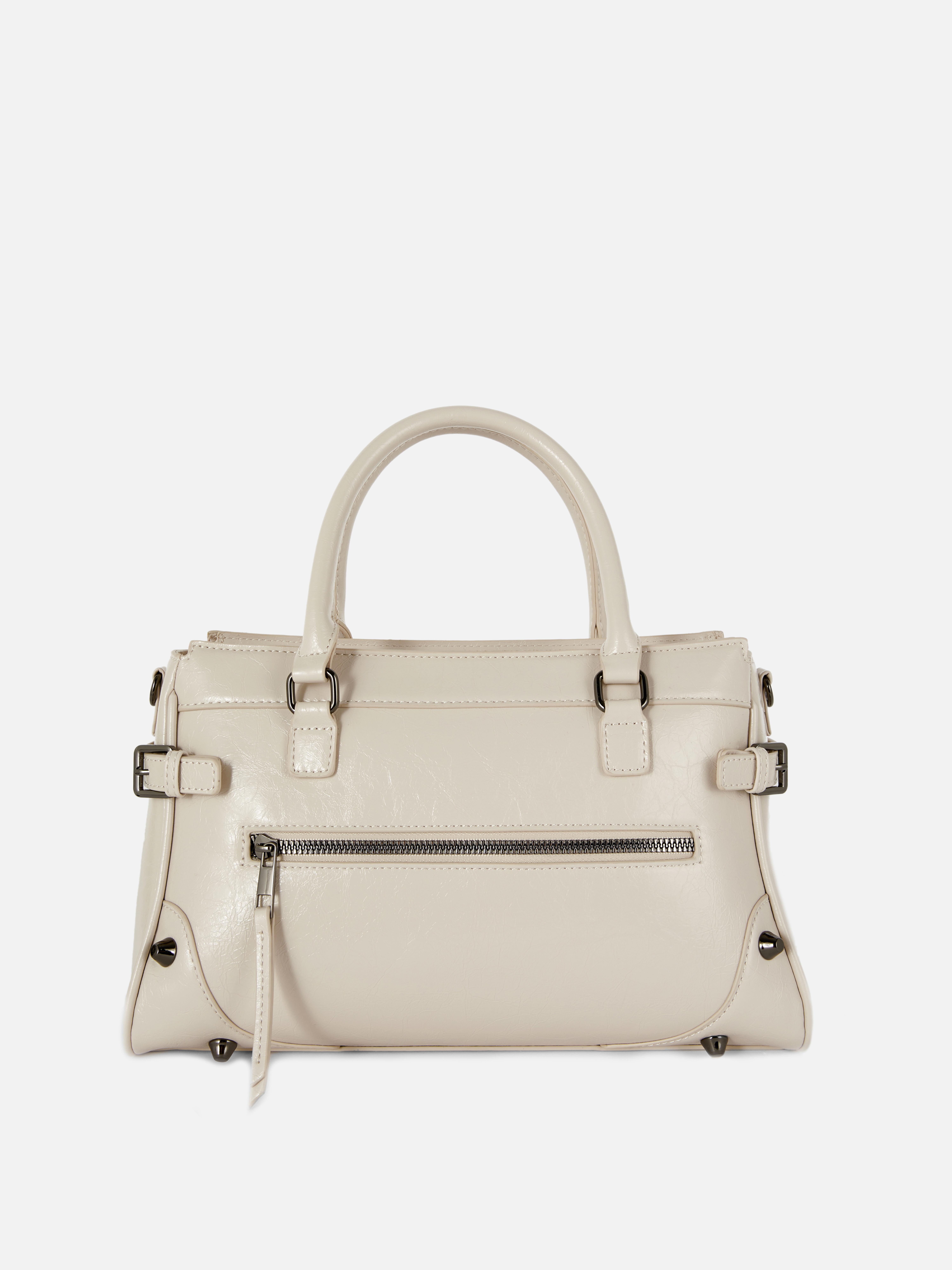 Abgenutzte Schultertasche aus Kunstleder. Eine mittellange Tragetasche aus Kunstleder mit Used-Look, mit Reißverschlusstaschen und Schnallendetails.