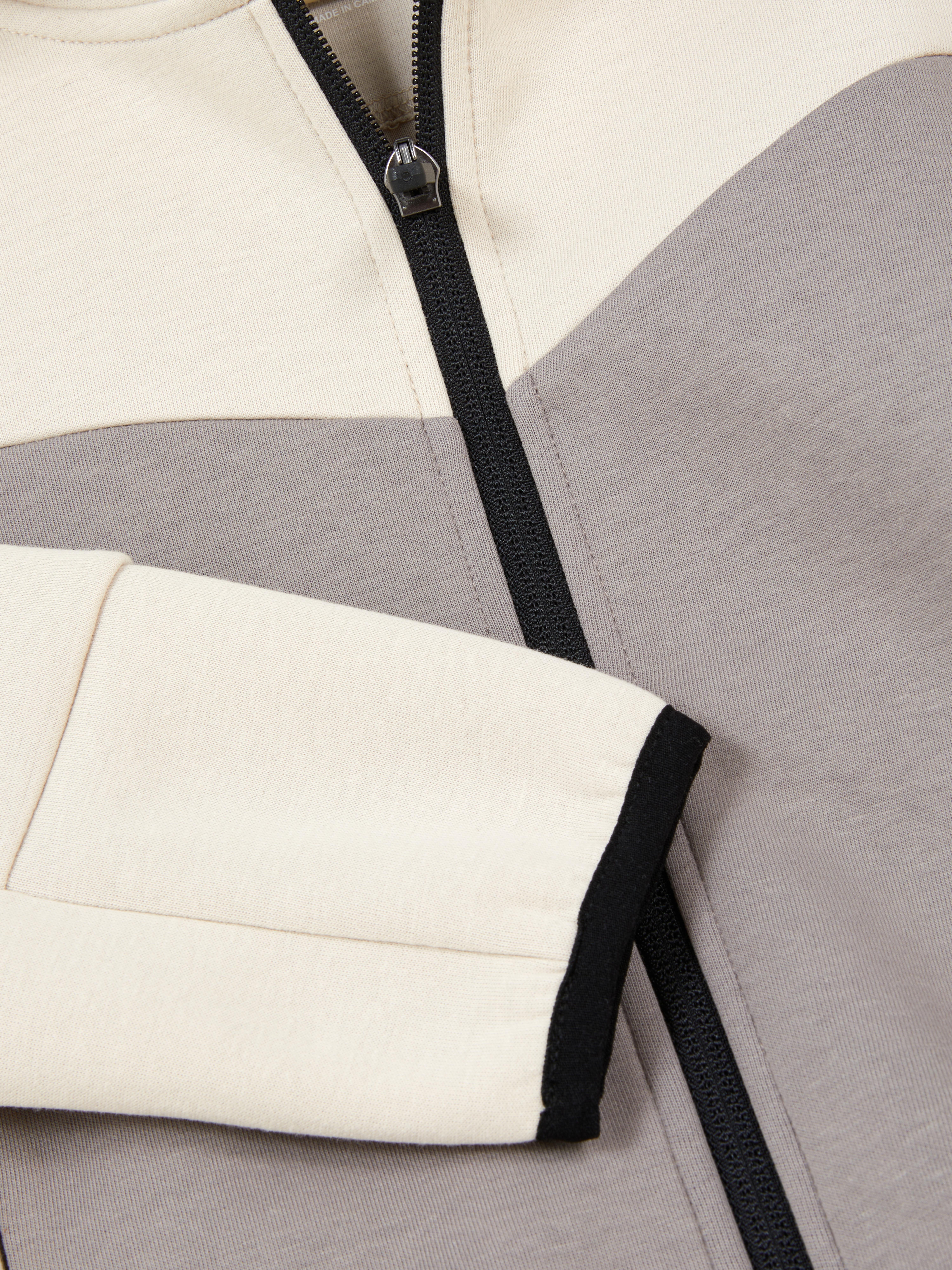 Passender Kapuzenpullover aus Verbundstoff mit Reißverschluss. Dieser Kapuzenpullover verfügt über einen Reißverschluss und Taschen.