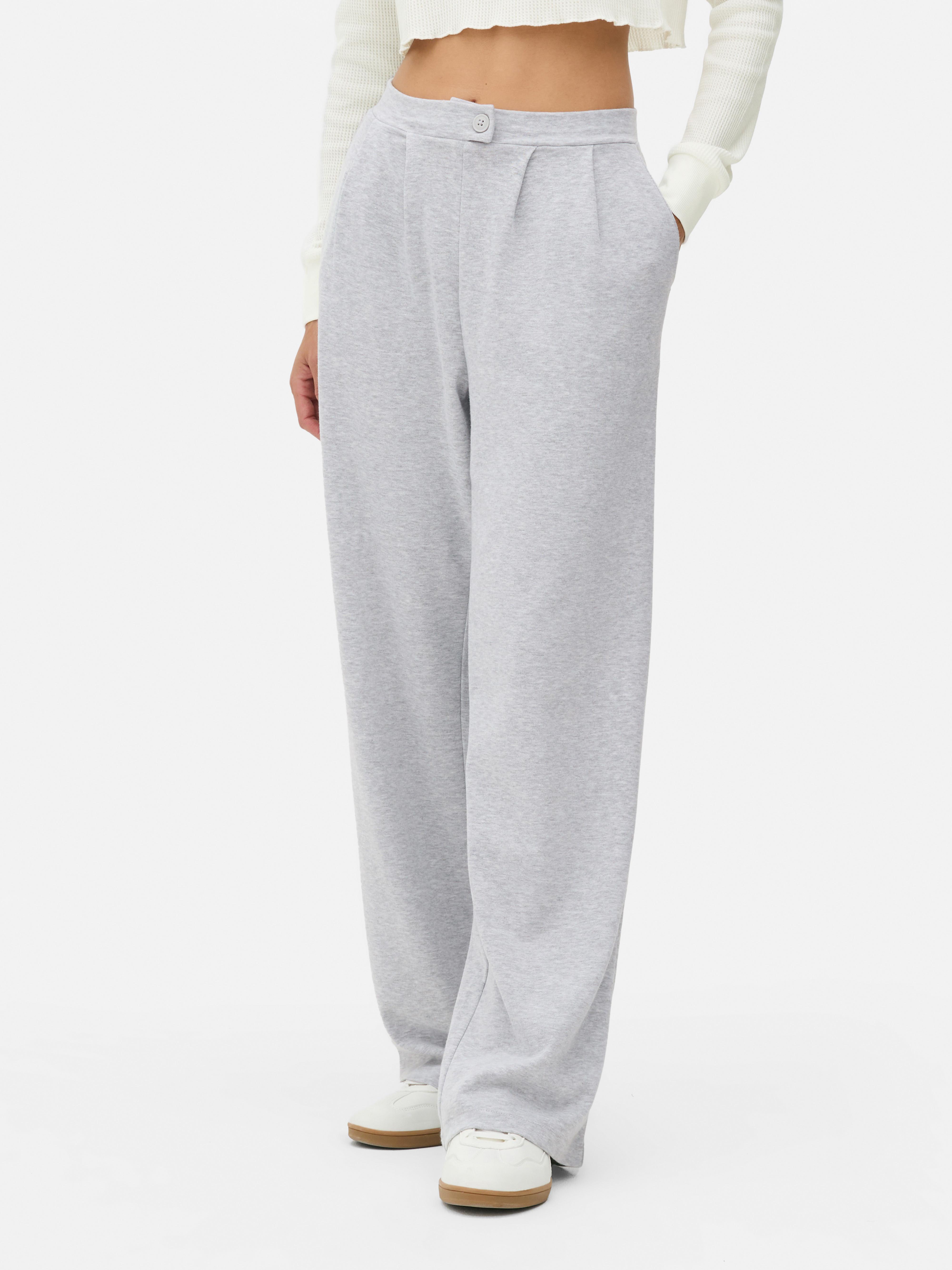 Pantaloni de trening din jerseu mulați. Acești pantaloni de trening au o fentă vizibilă cu nasturi și o siluetă elegantă.