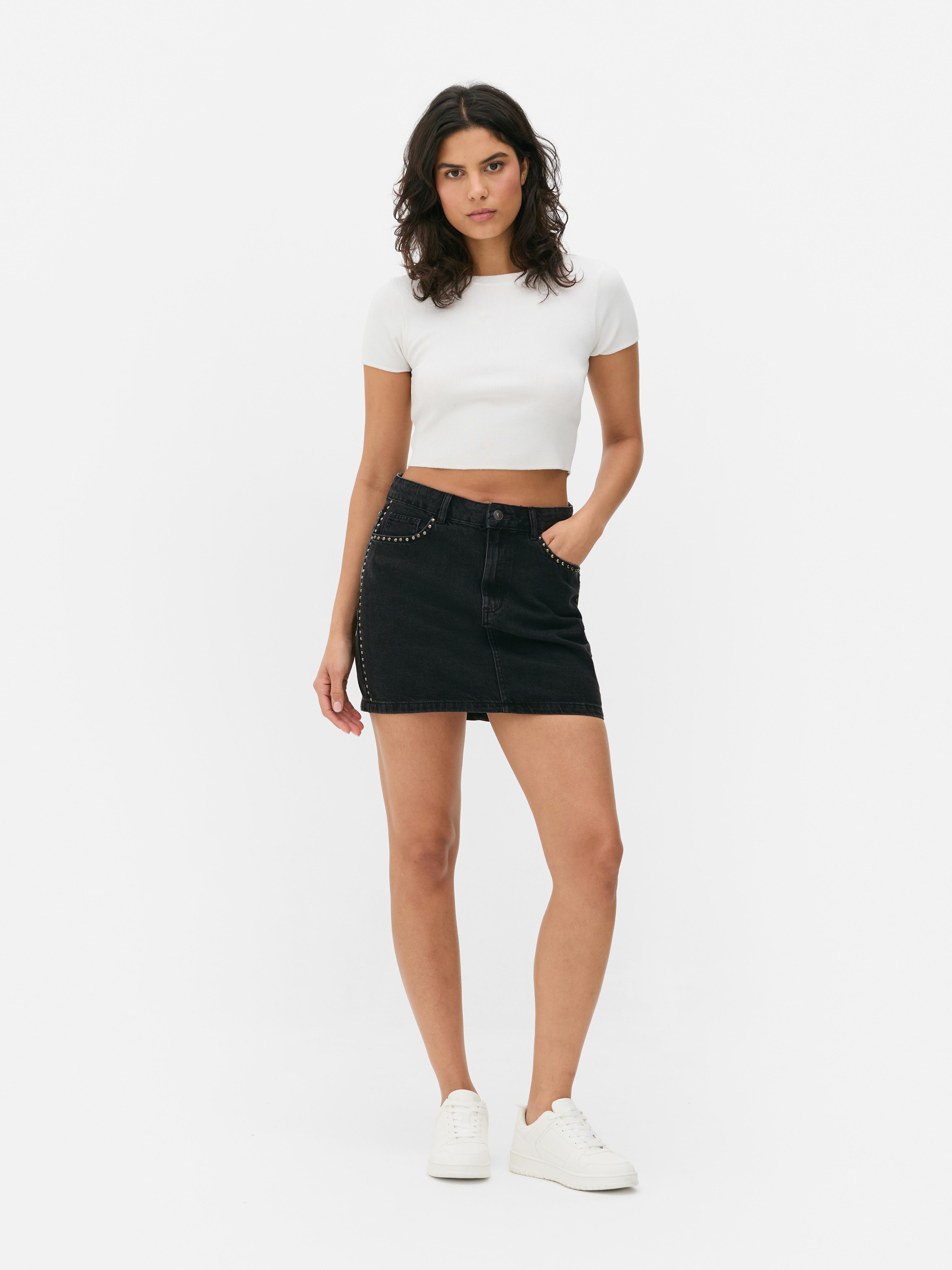 Fustă mini din denim cu ținte. Această fustă mini are cinci buzunare, găici pentru curea și fermoar.