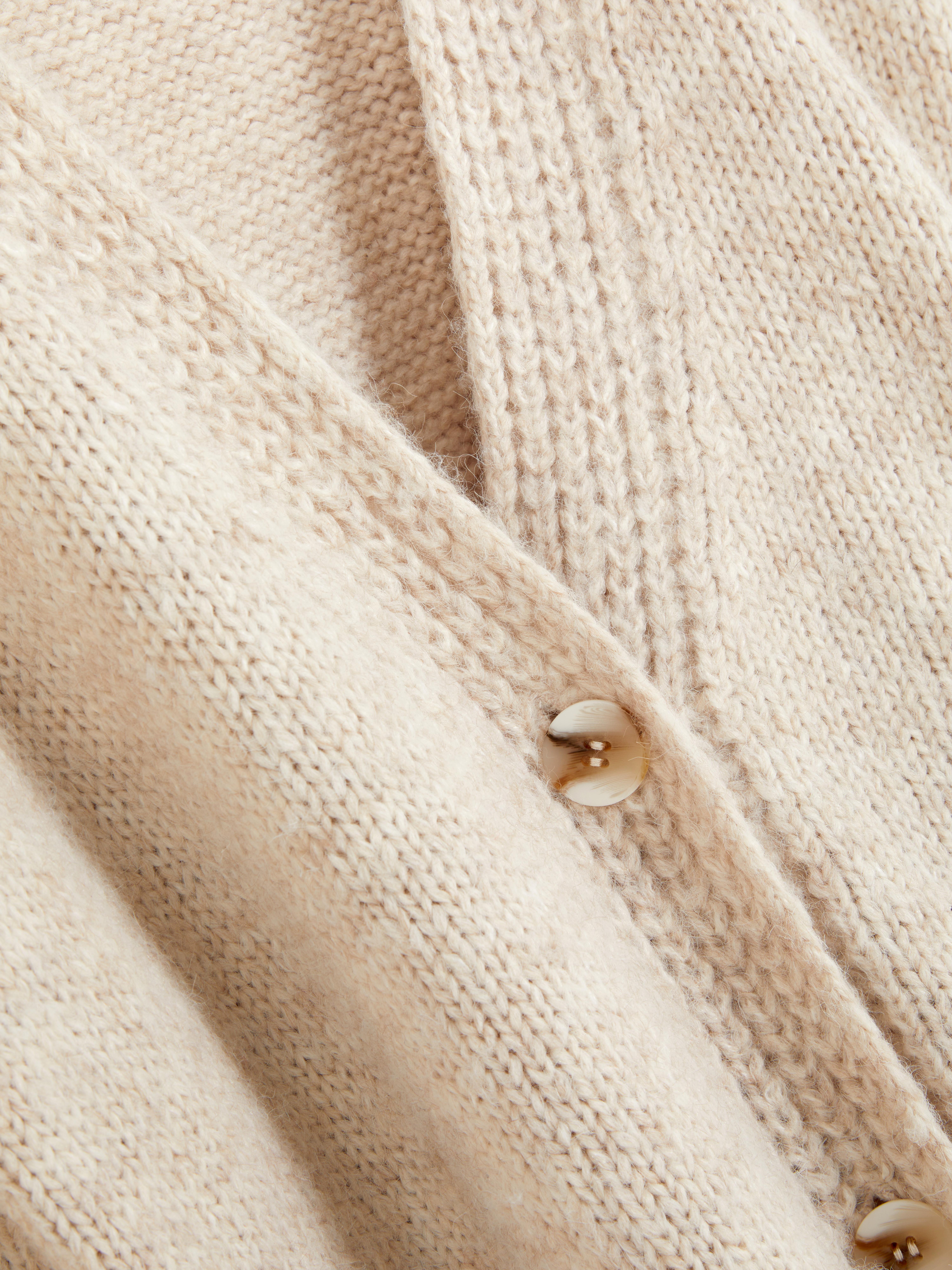 Oversize-Strickjacke. Eine lange Strickjacke mit Oversize-Schnitt, V-Ausschnitt und aufgesetzten Taschen.