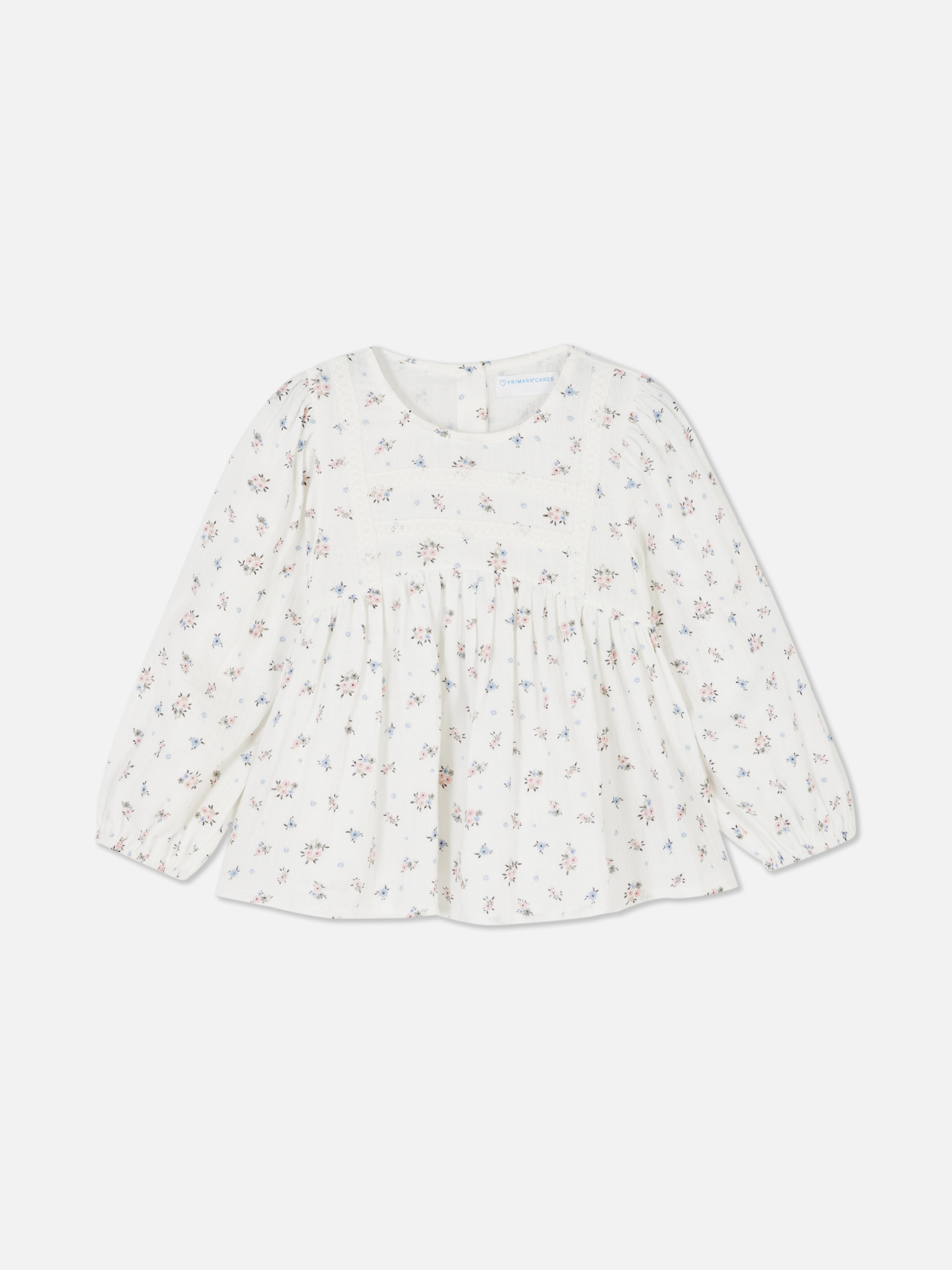 Langärmlige Bluse mit Blumenmuster Eine langärmlige Bluse mit Blumenmuster und Knopfverschluss am Rücken