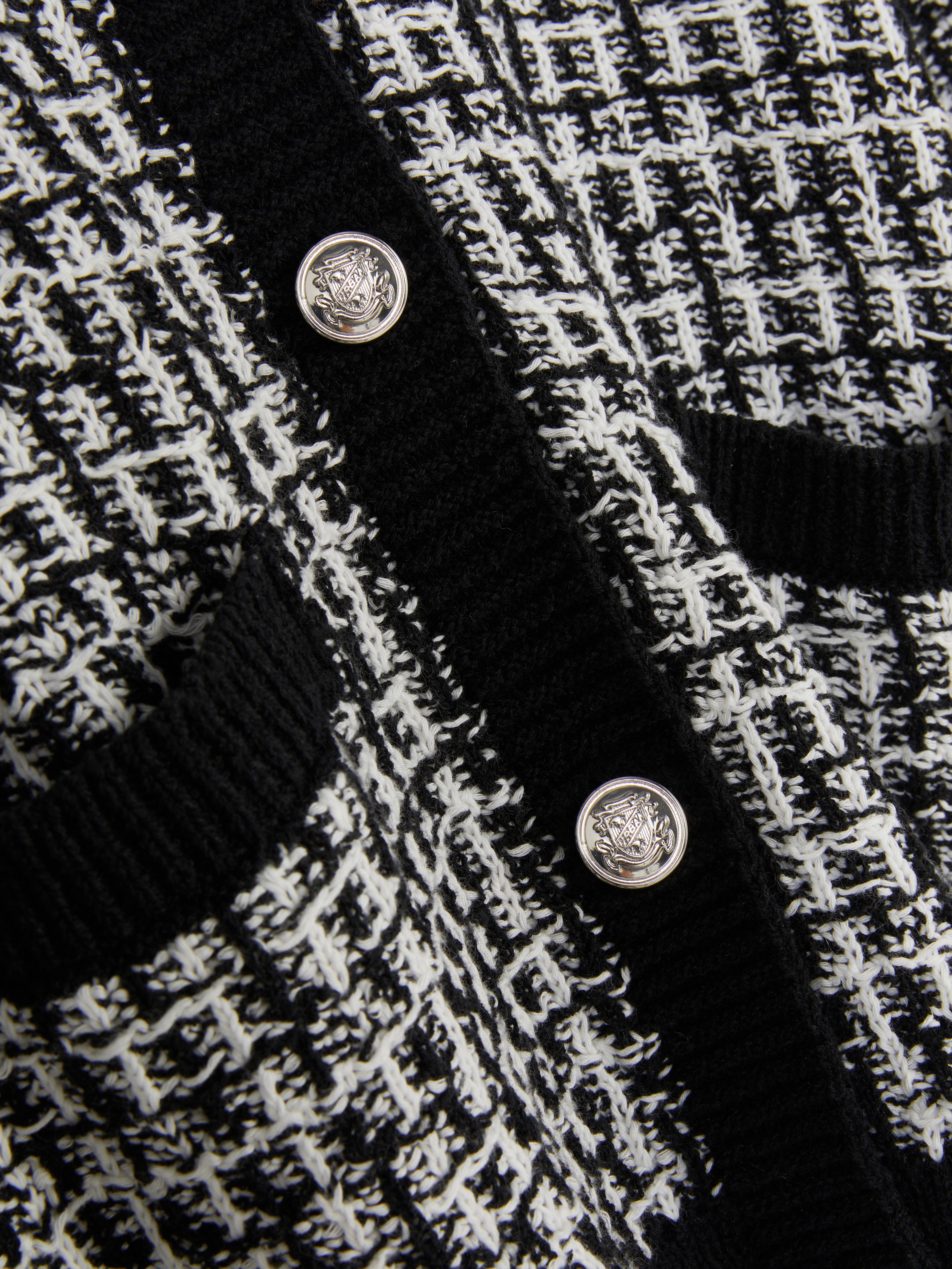 Tweed-Strickjacke mit Knöpfen. Eine Tweed-Strickjacke mit Knopfleiste, gerippten Bündchen und Taschen.