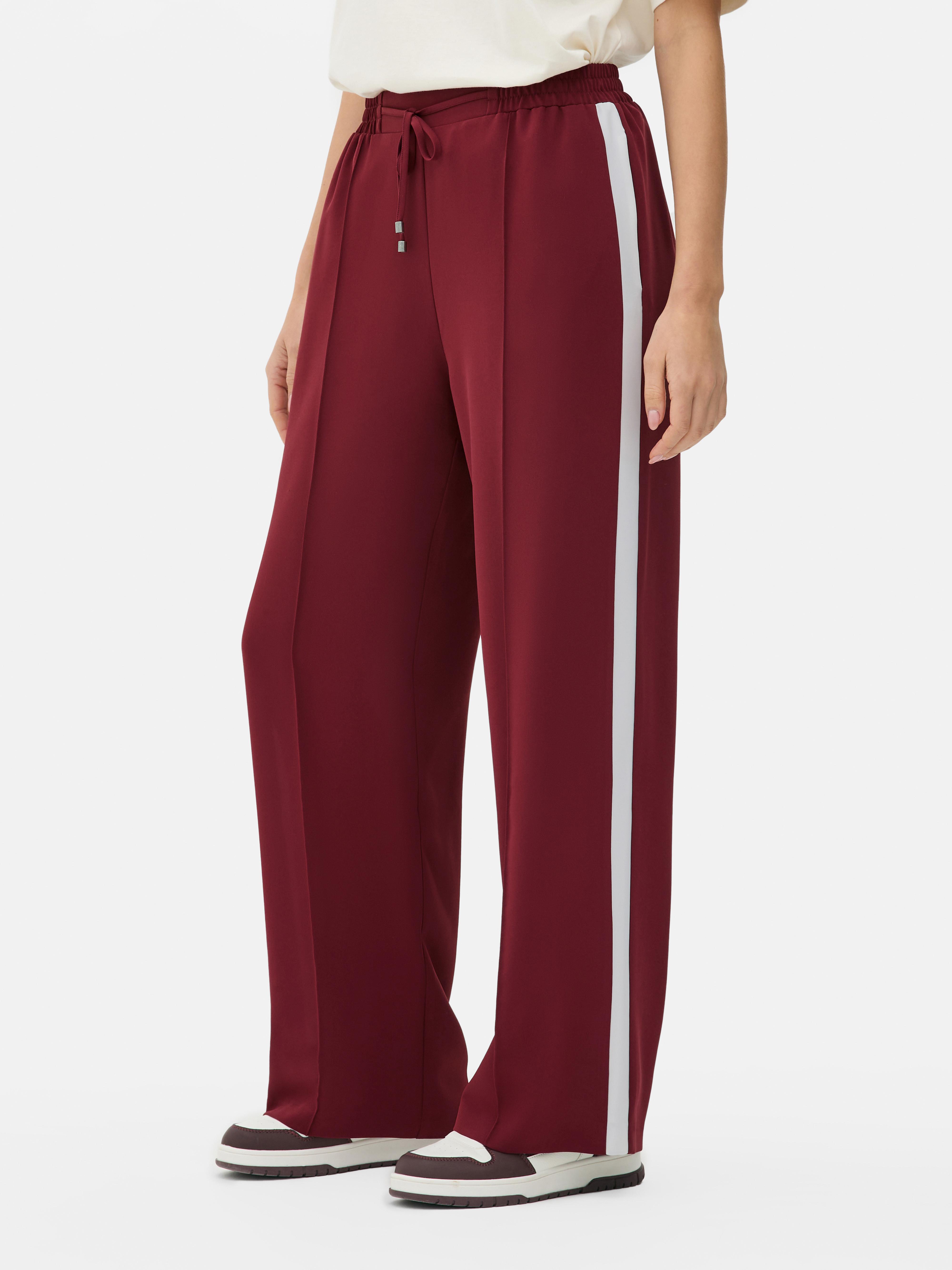Pantaloni da jogging con striscia laterale. Questi pantaloni a gamba larga, con strisce a contrasto e vita elasticizzata, sono allo stesso tempo funzionali ed eleganti.