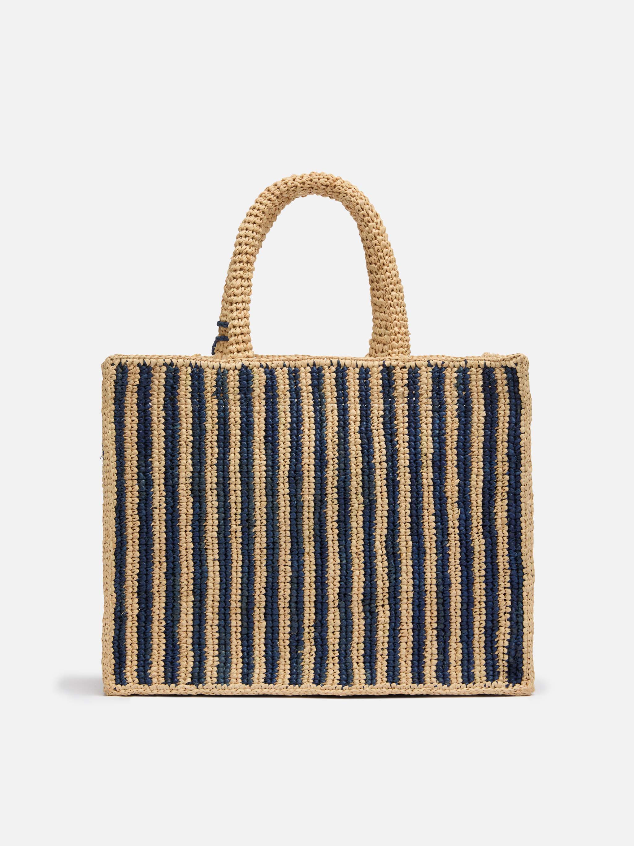 Colette-tas van marineblauwe gestreepte raffia met geborduurd logo.