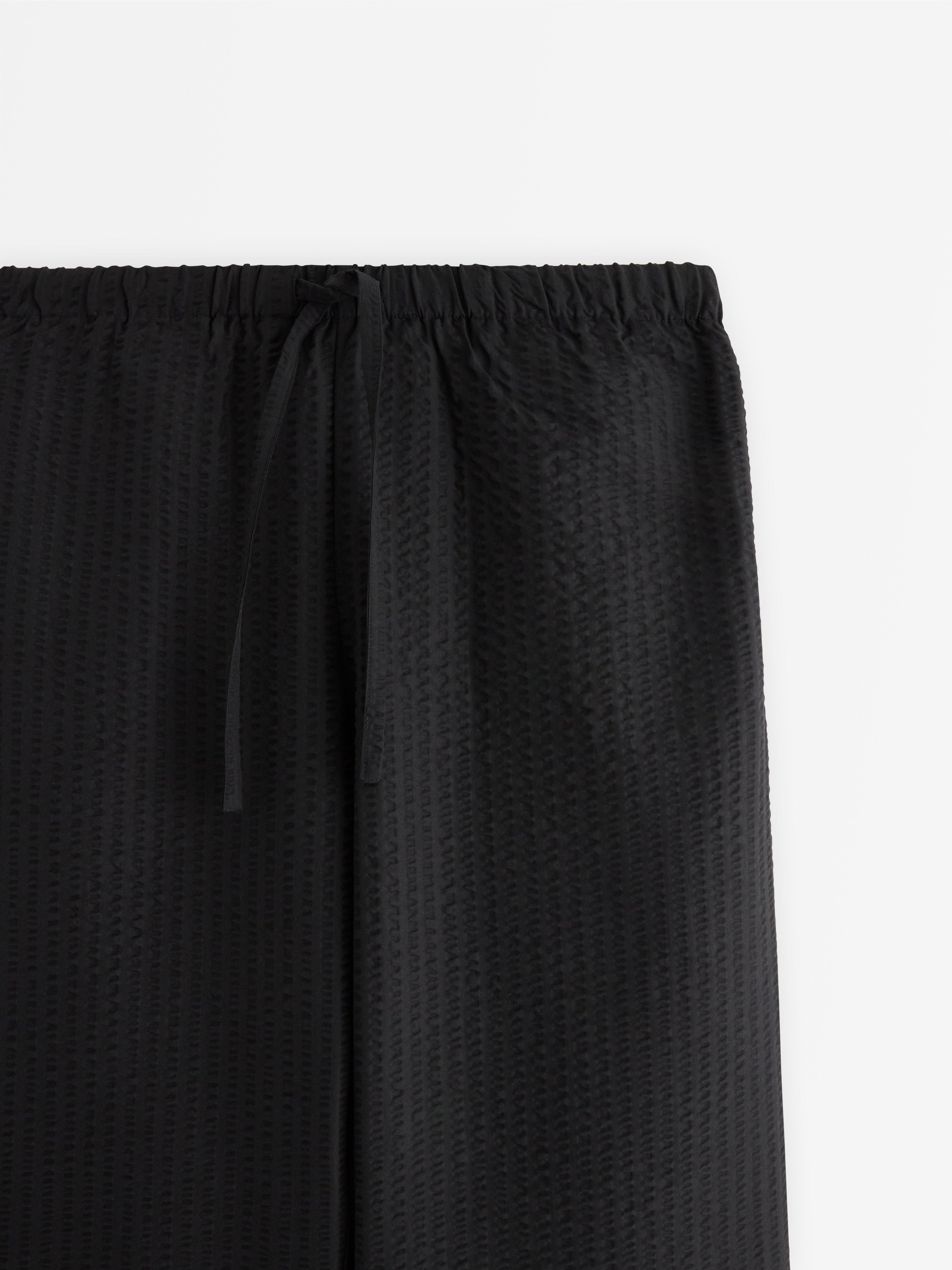 Pantalones rectos acampanados de color negro