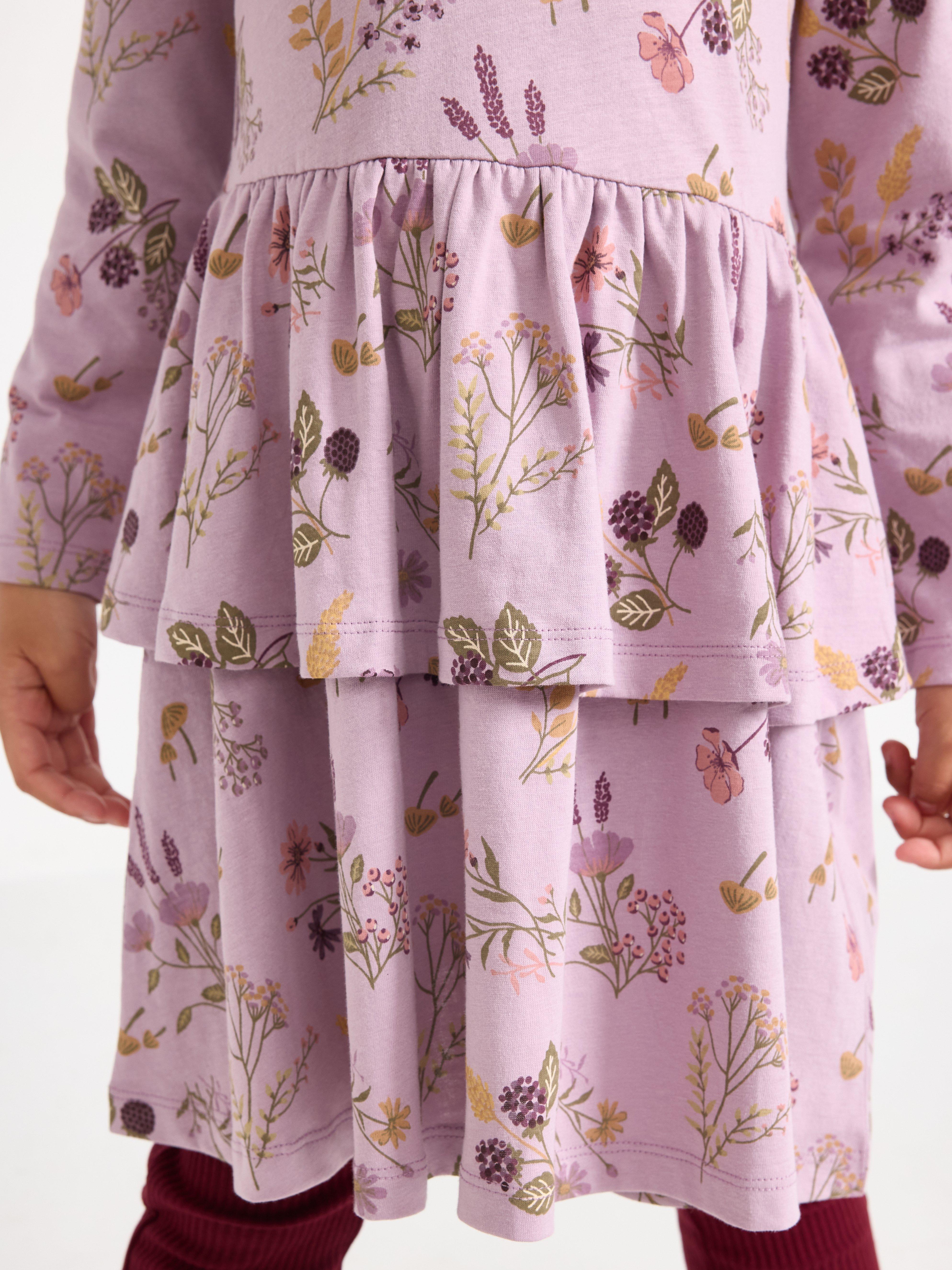 Vestido de mangas compridas na cor lilás claro.