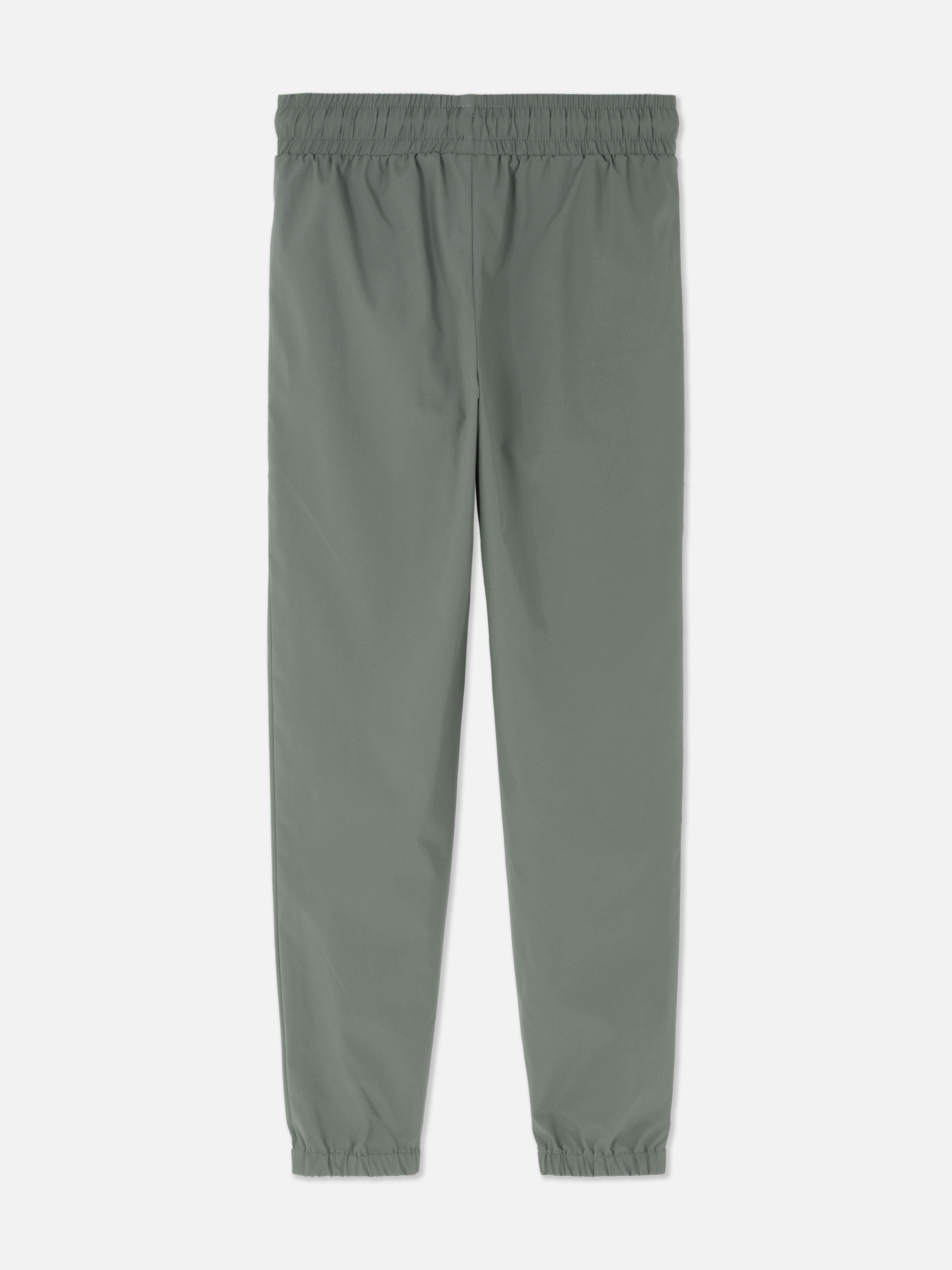 Pantaloni sport de jogging cu talie conică. Pantaloni de jogging cu talie cu șnur, buzunare cu fermoar și manșete la gleznă.