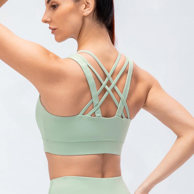 Intimo sportivo in nylon effetto nudo da donna, reggiseno yoga sexy con spalline incrociate sulla schiena, top corti da fitness con imbottiture per il seno, abbigliamento da palestra femminile