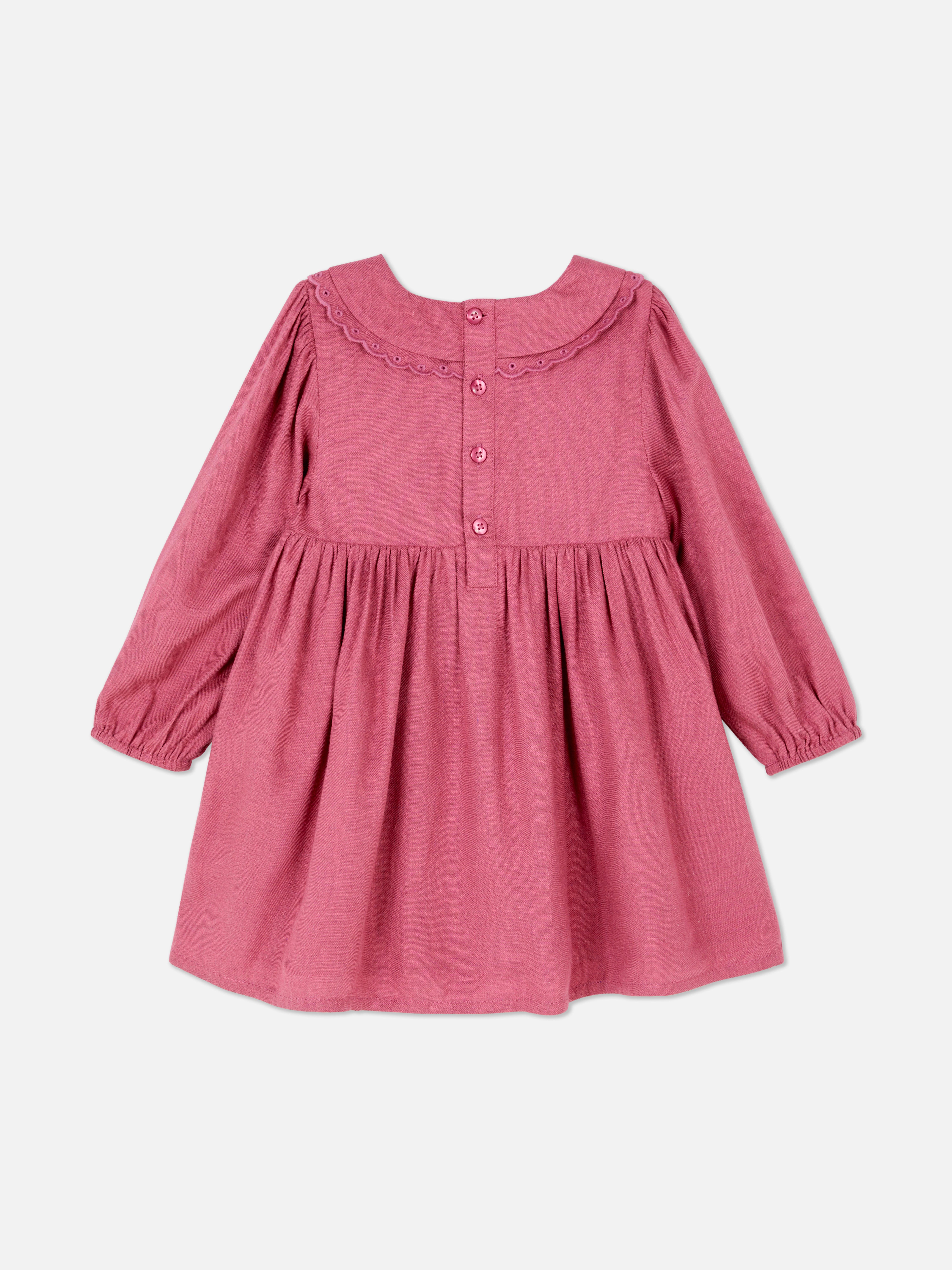 Rochie cu broderie florală. O rochie vaporoasă cu guler Peter Pan, mâneci lungi și închizătoare la spate.
