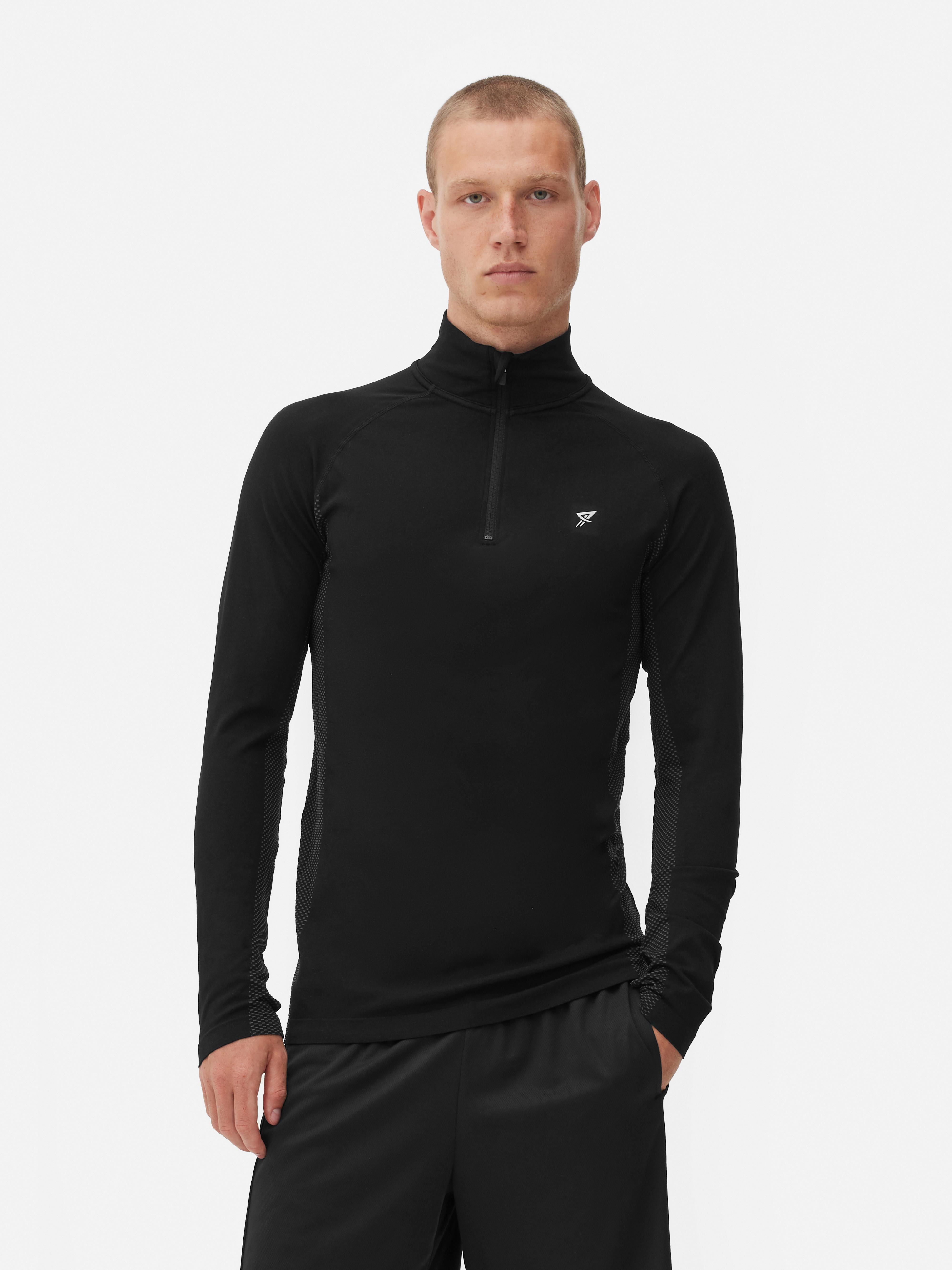 Top sport cu fermoar cu un sfert și mâneci lungi Un top sport cu mâneci lungi, guler ridicat, închidere cu fermoar cu un sfert și tiv drept