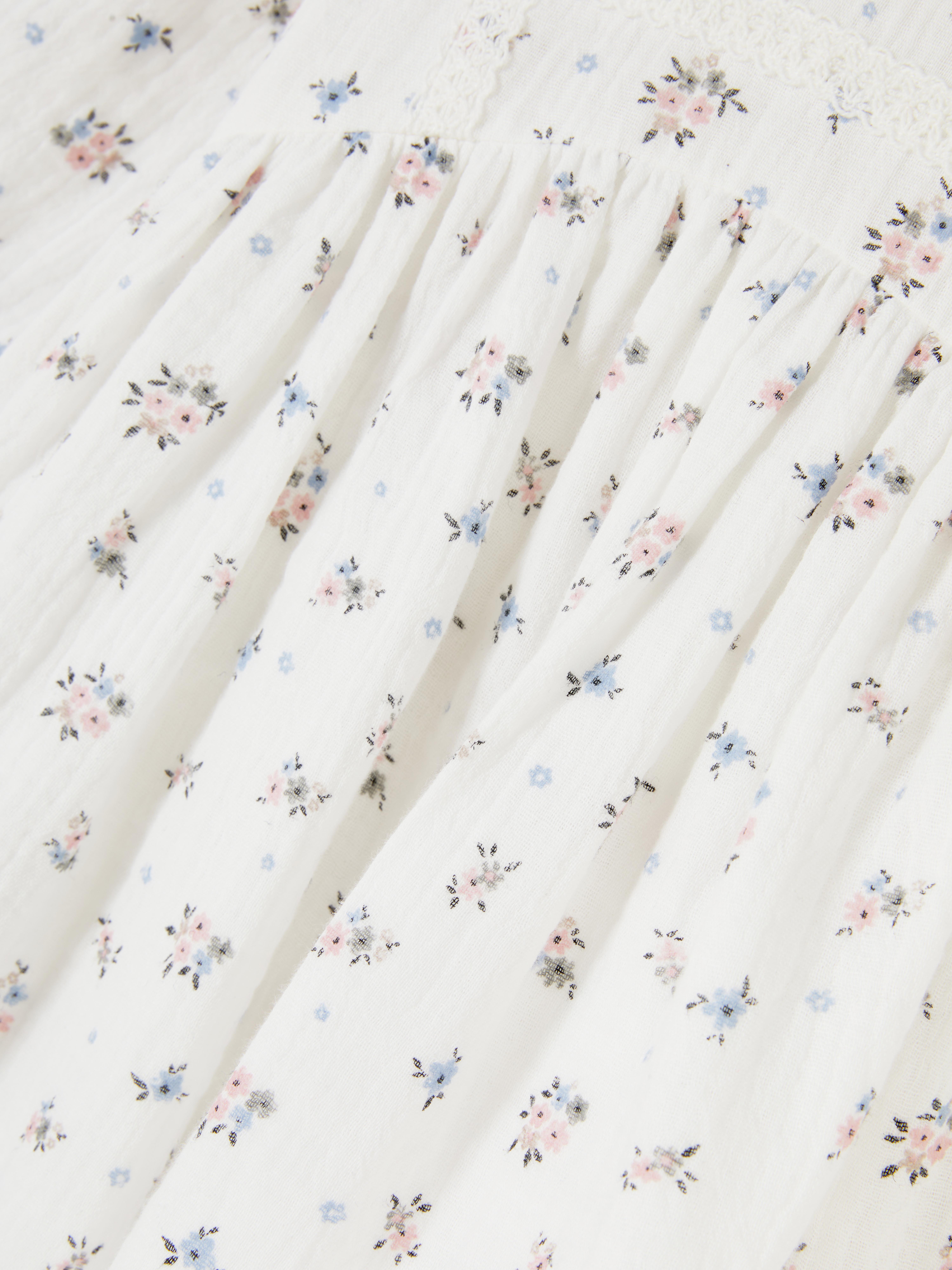 Langärmlige Bluse mit Blumenmuster Eine langärmlige Bluse mit Blumenmuster und Knopfverschluss am Rücken