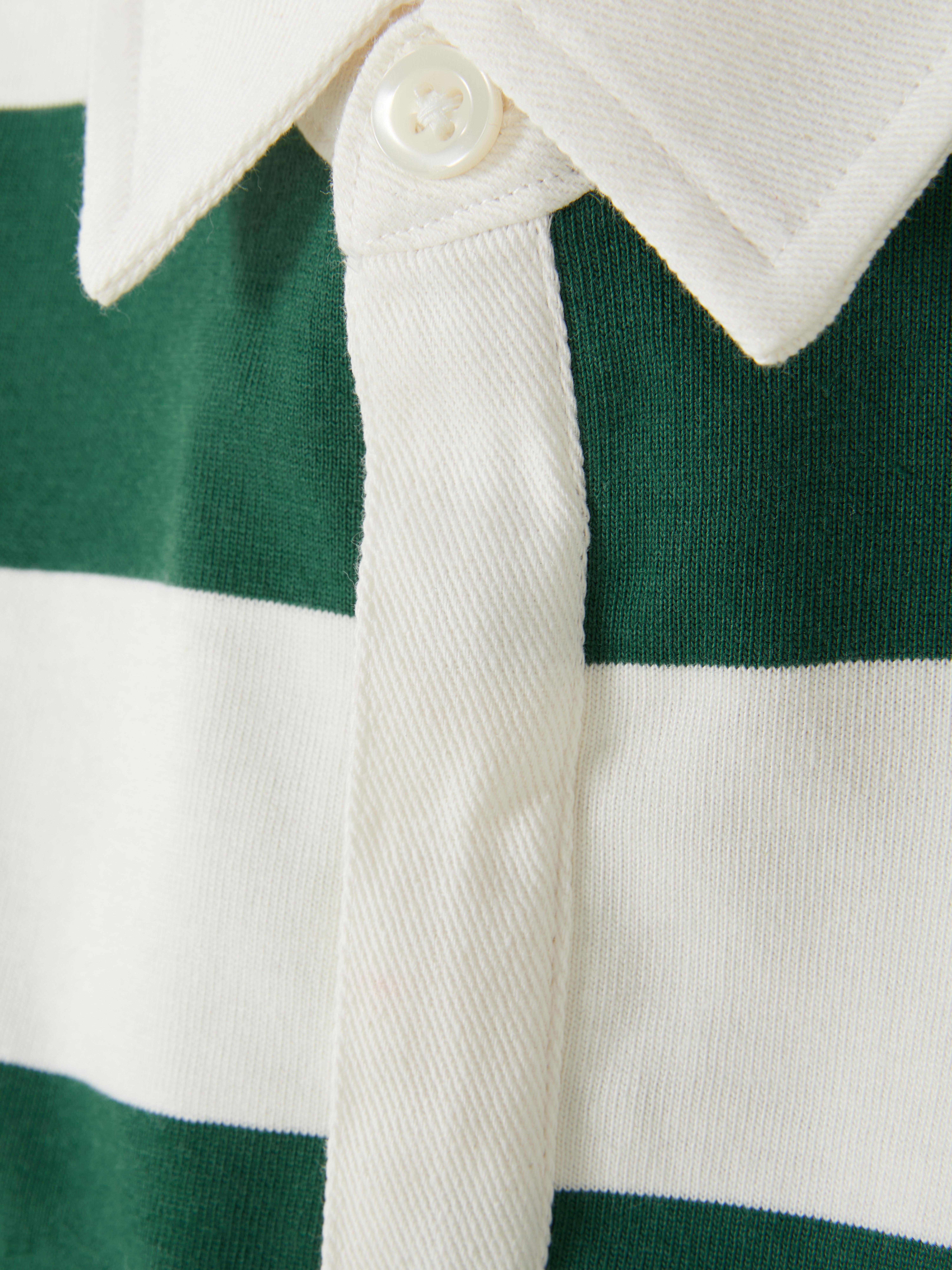 Tricou polo de rugby Un tricou polo de rugby cu dungi, cu guler, fentă cu nasturi și mâneci lungi cu manșete