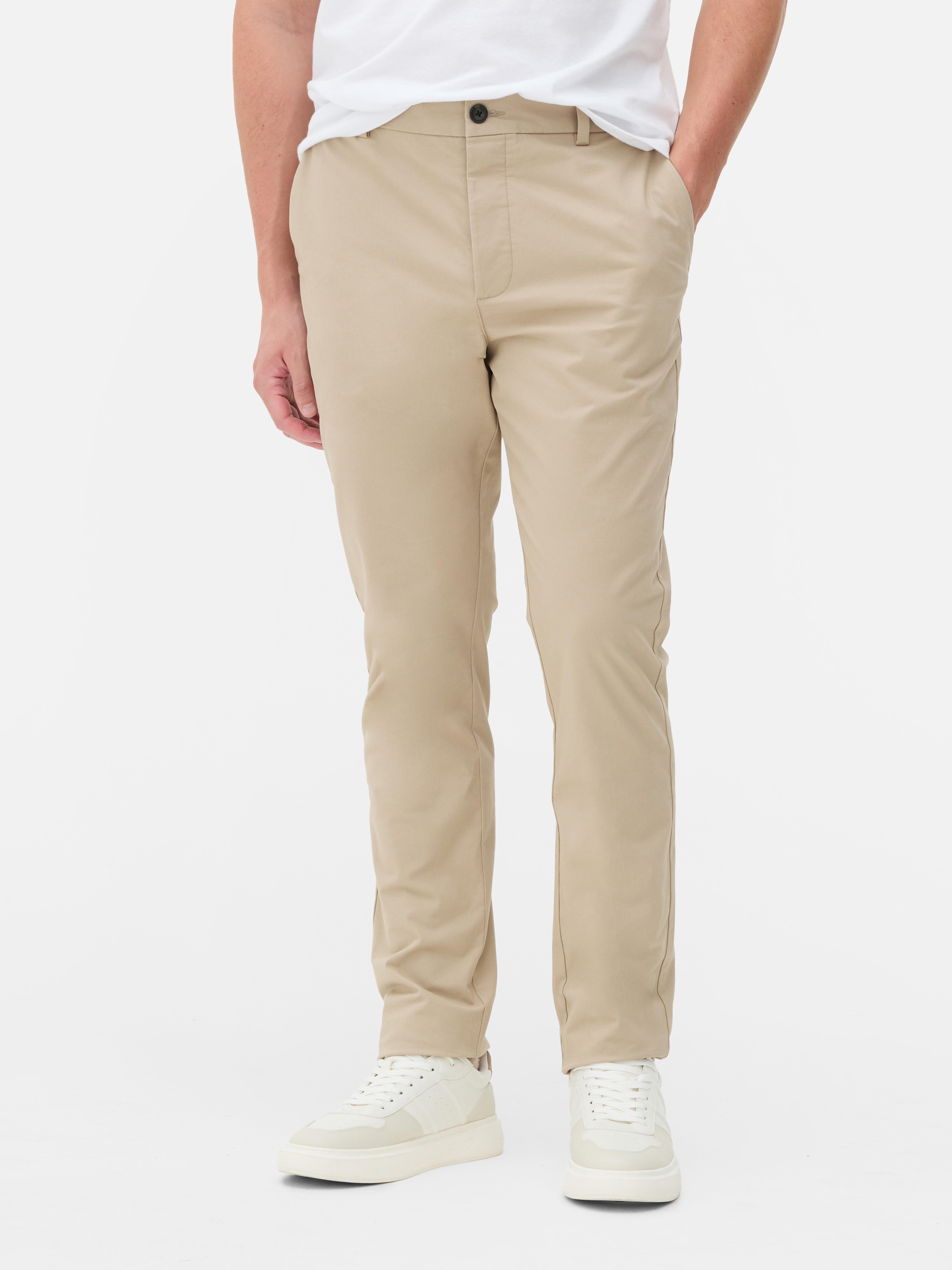 Pantaloni chino elastici, mulați. Pantaloni chino mulați, confecționați în principal din bumbac și cu buzunare laterale.