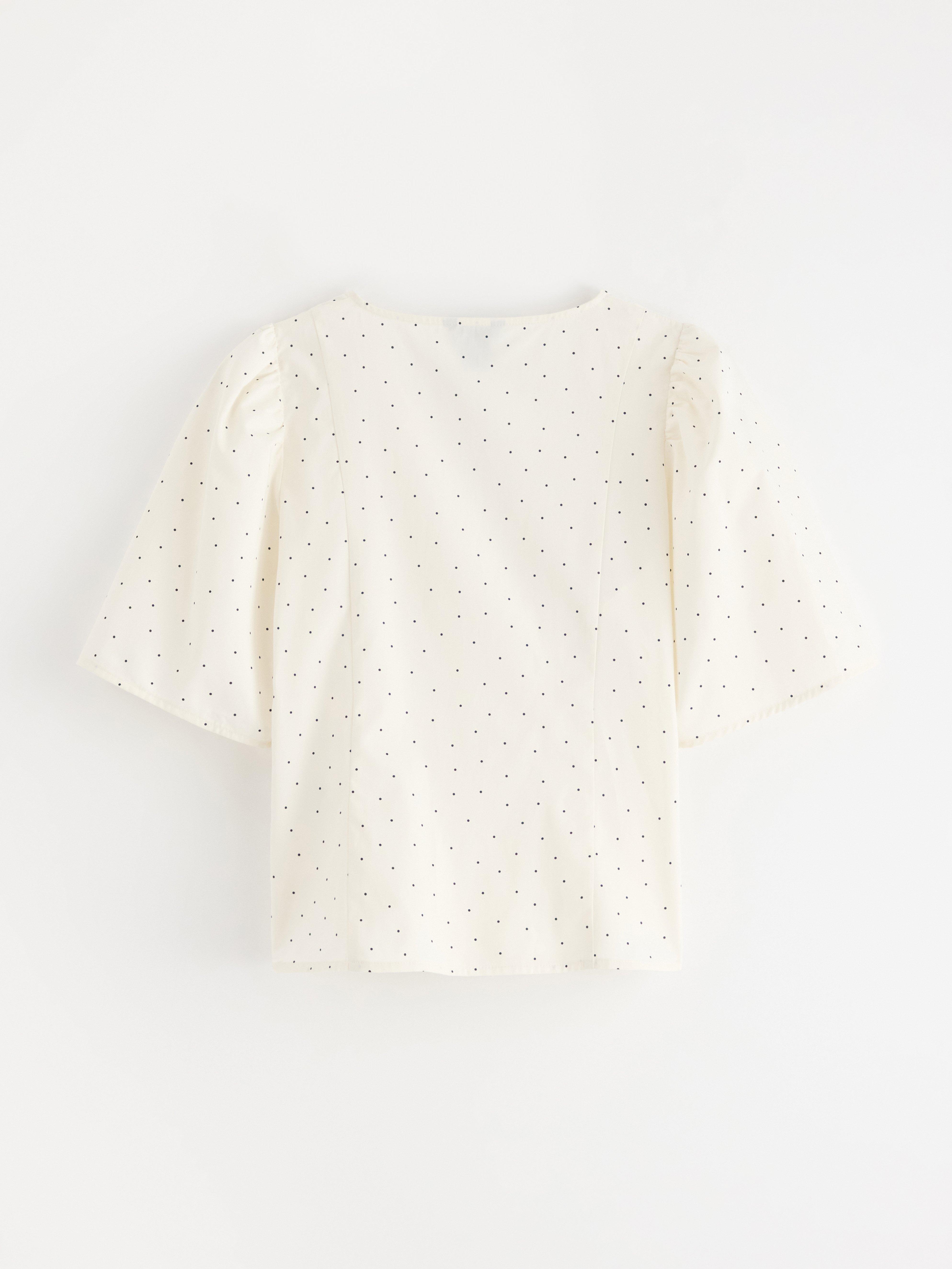 Blusa con diseño cruzado, color blanco claro.