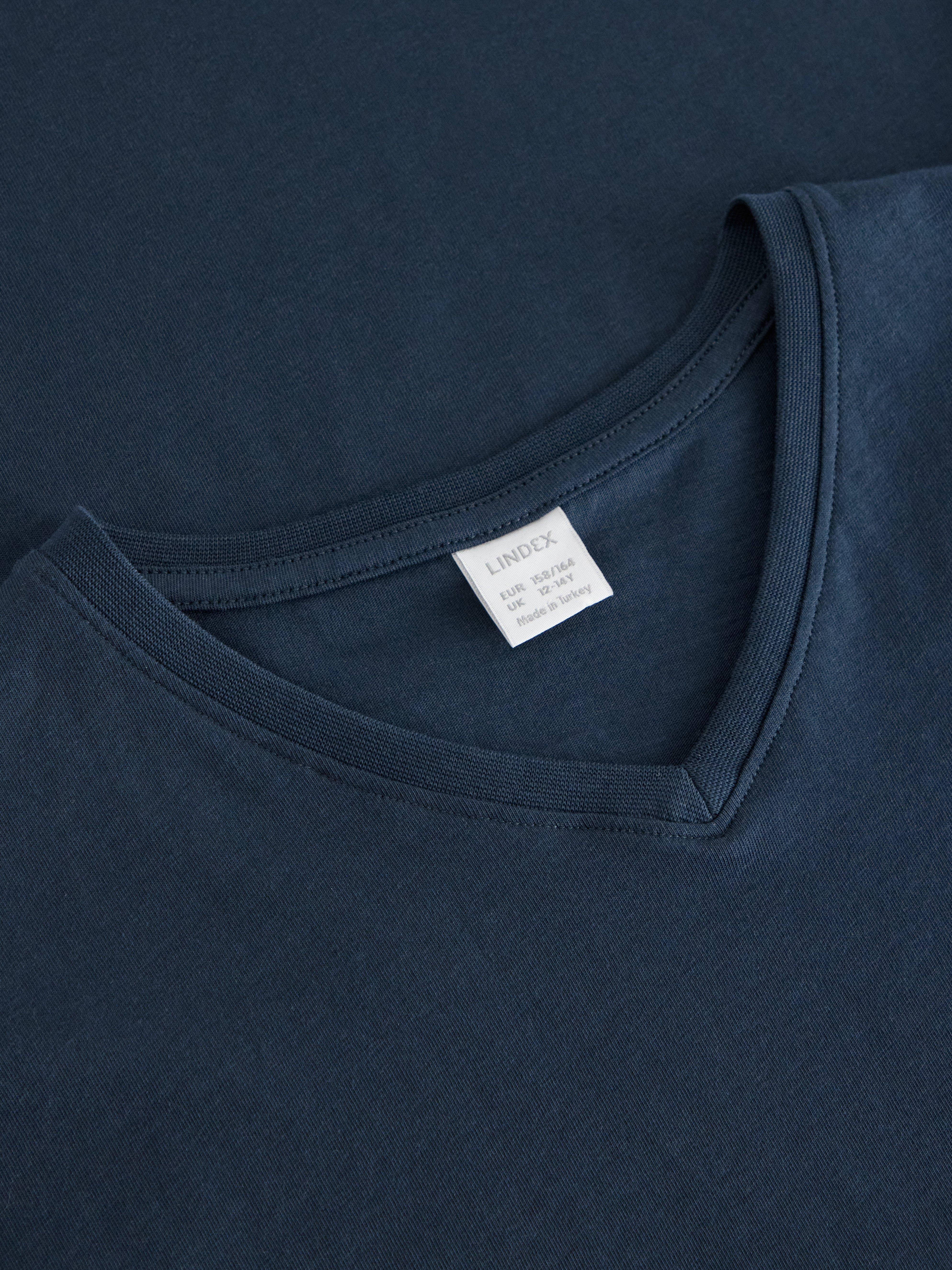 Camiseta con cuello en V, color azul marino oscuro.