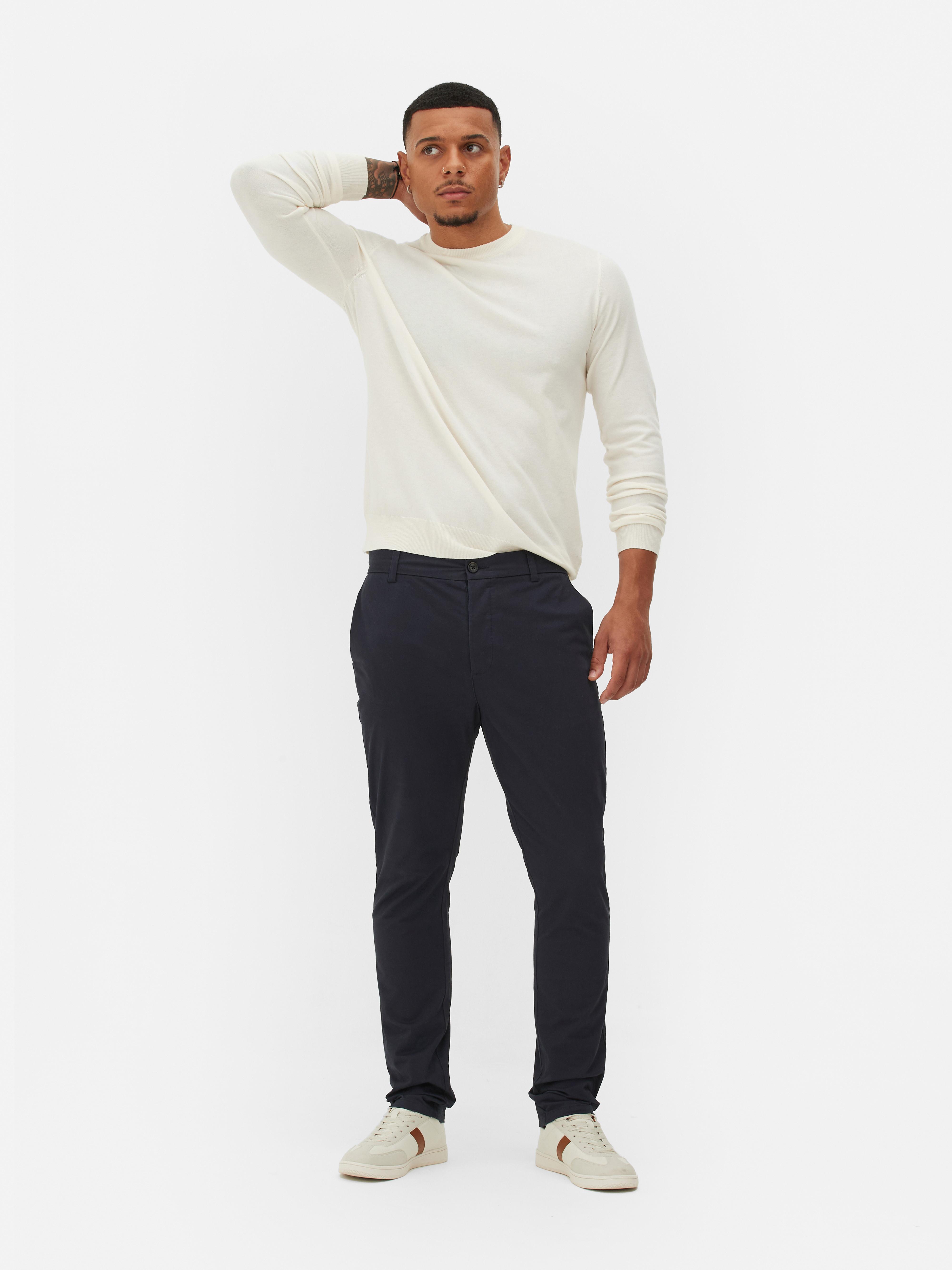 Pantaloni chino elastici, mulați. Pantaloni chino mulați, confecționați în principal din bumbac și cu buzunare laterale.