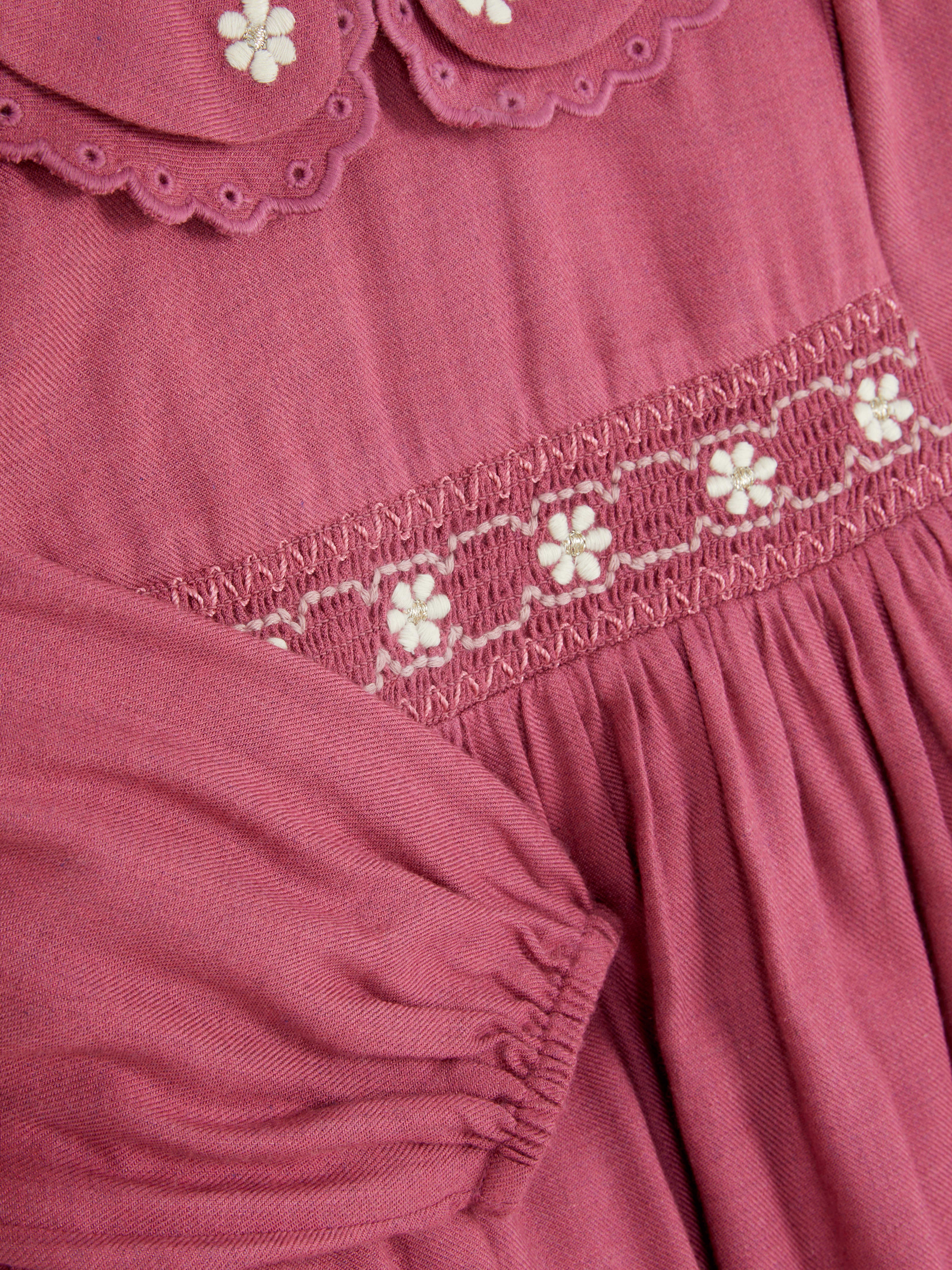 Rochie cu broderie florală. O rochie vaporoasă cu guler Peter Pan, mâneci lungi și închizătoare la spate.