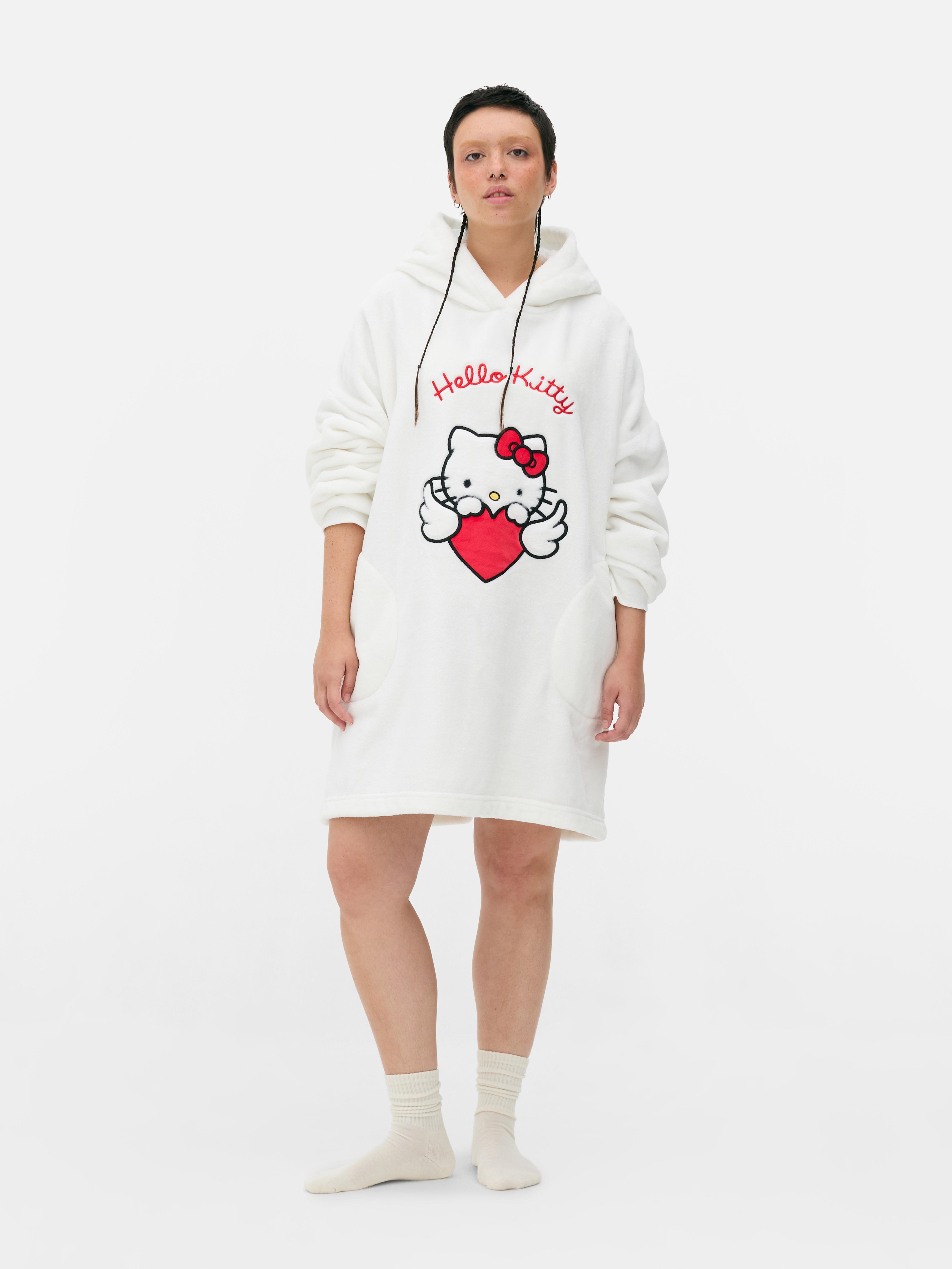 Snuddie Hello Kitty O snuddie Hello Kitty cu glugă, urechi decorative și fundă roșie emblematică