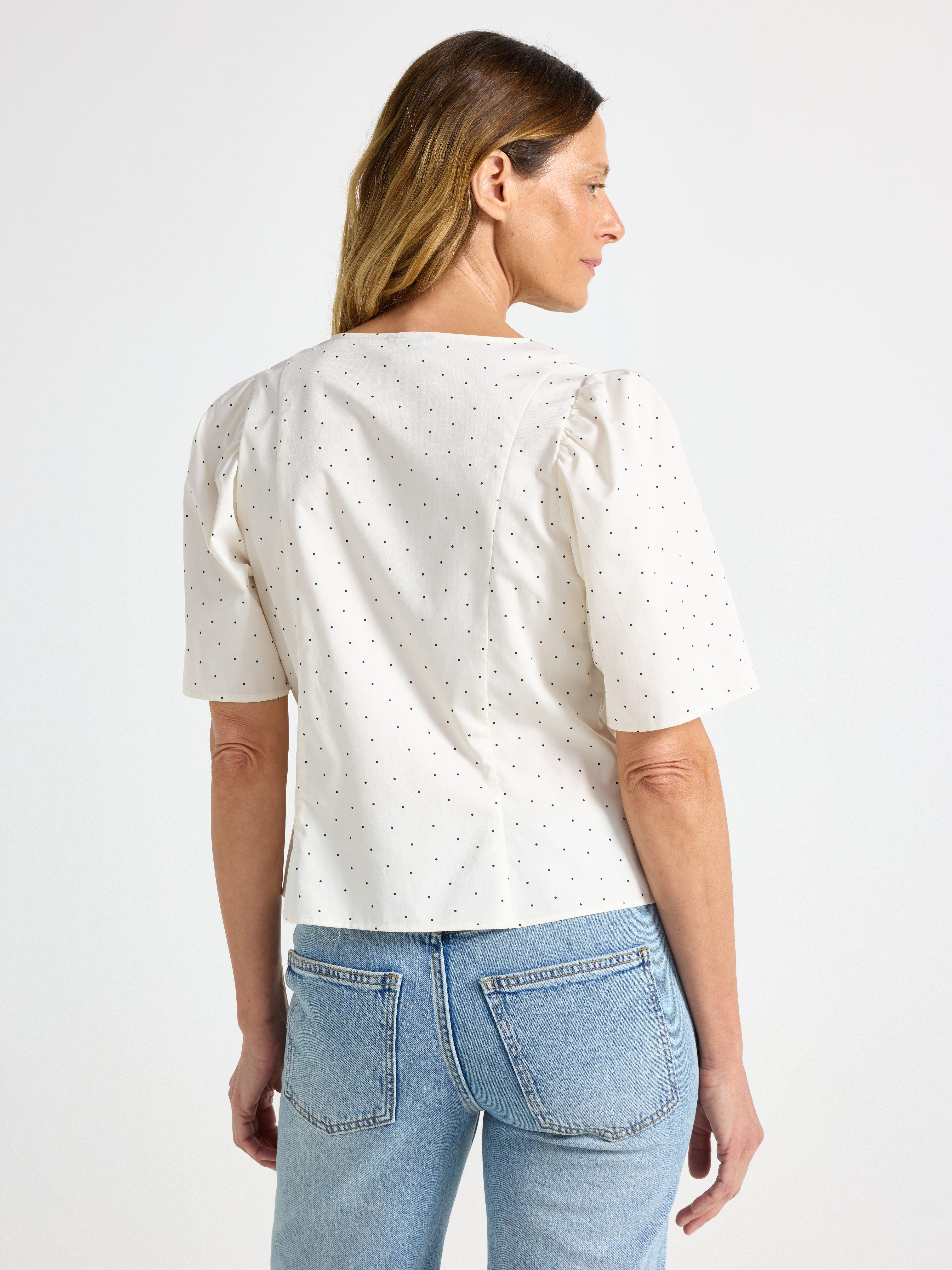 Blusa com modelagem transpassada, branca clara.