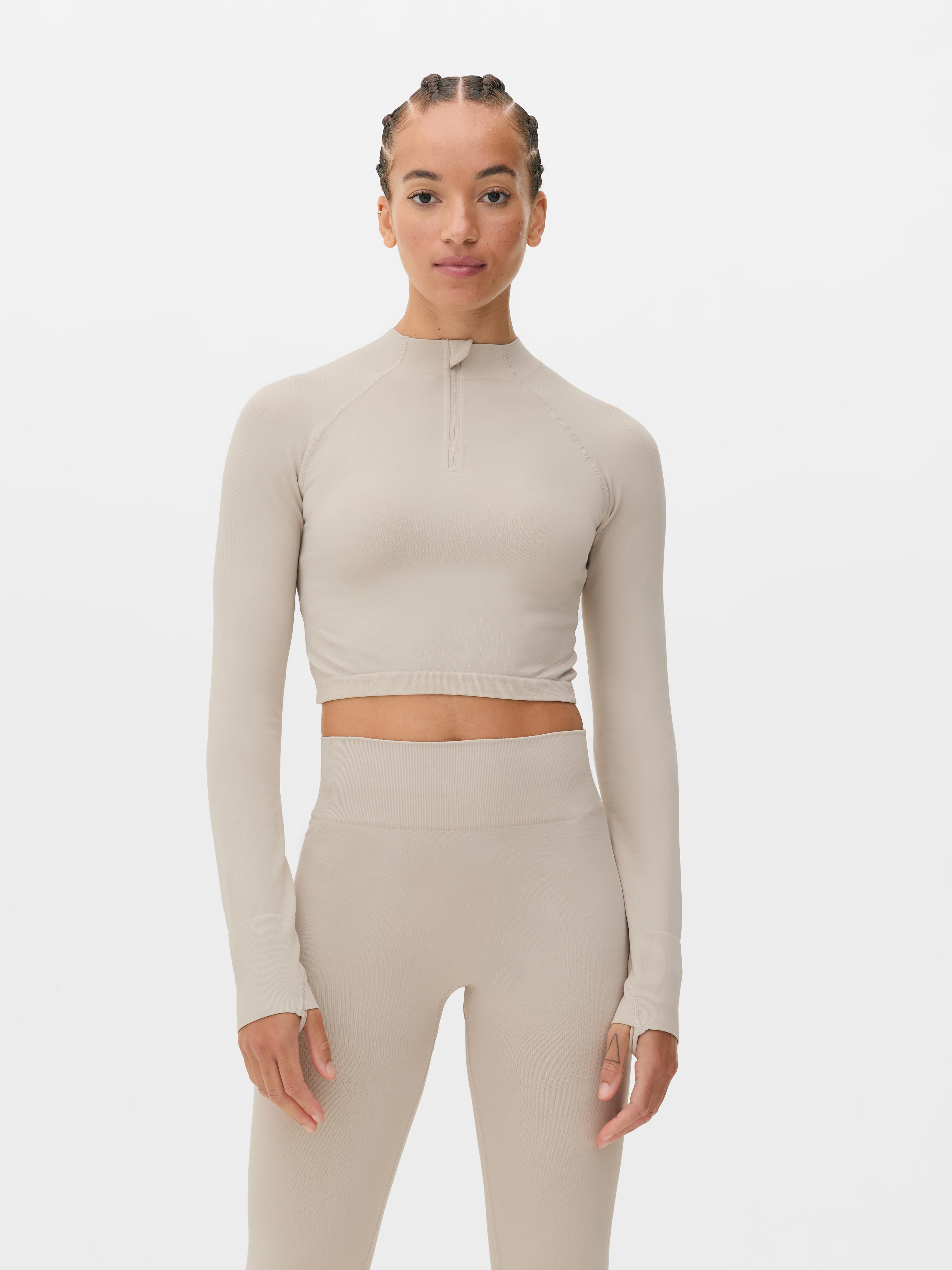 Top sport modelator cu mâneci lungi, fără cusături. Acest top sport scurt, cu fermoar pe jumătate și design fără cusături, este funcțional și elegant.
